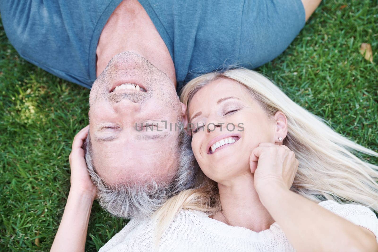 Mature, happy couple and outdoor relax on grass from above for marriage anniversary, travel or relationship. Man, woman and top view in garden park in New Zealand for holiday trip, peace or nature by YuriArcurs