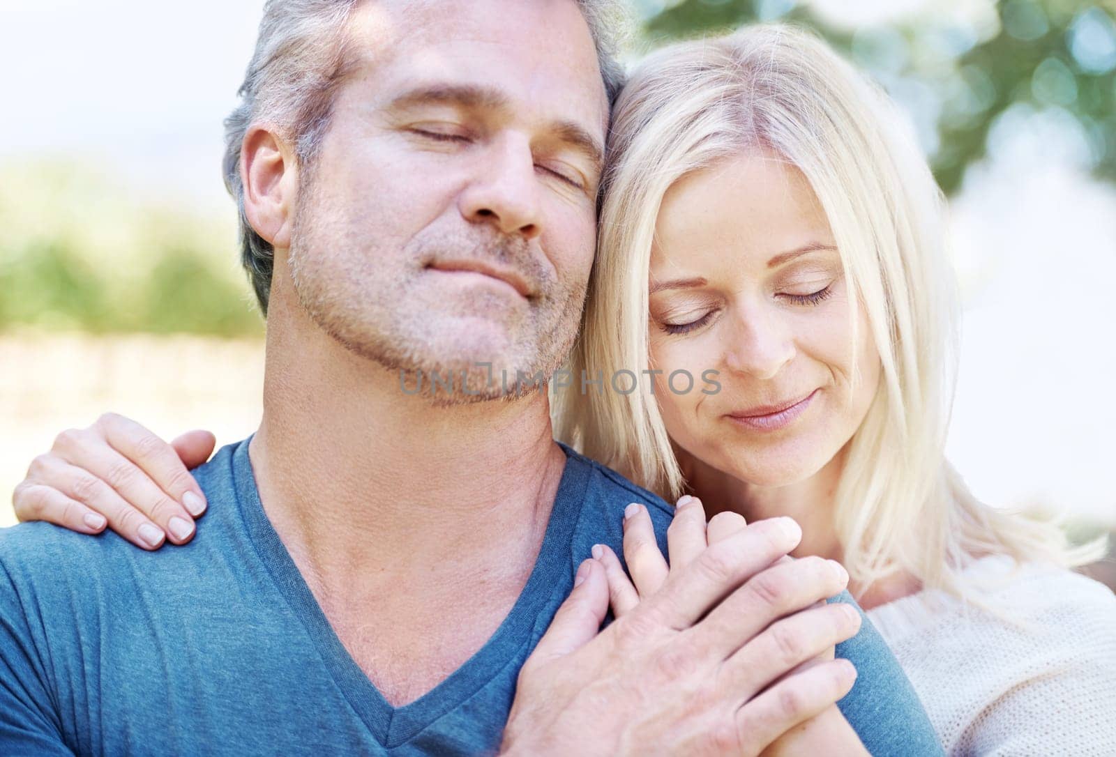 Love, hug and senior couple in park for bonding, relationship and commitment outdoors on weekend. Eyes closed, retirement and mature man and woman embrace for romance, relaxing and marriage in nature.
