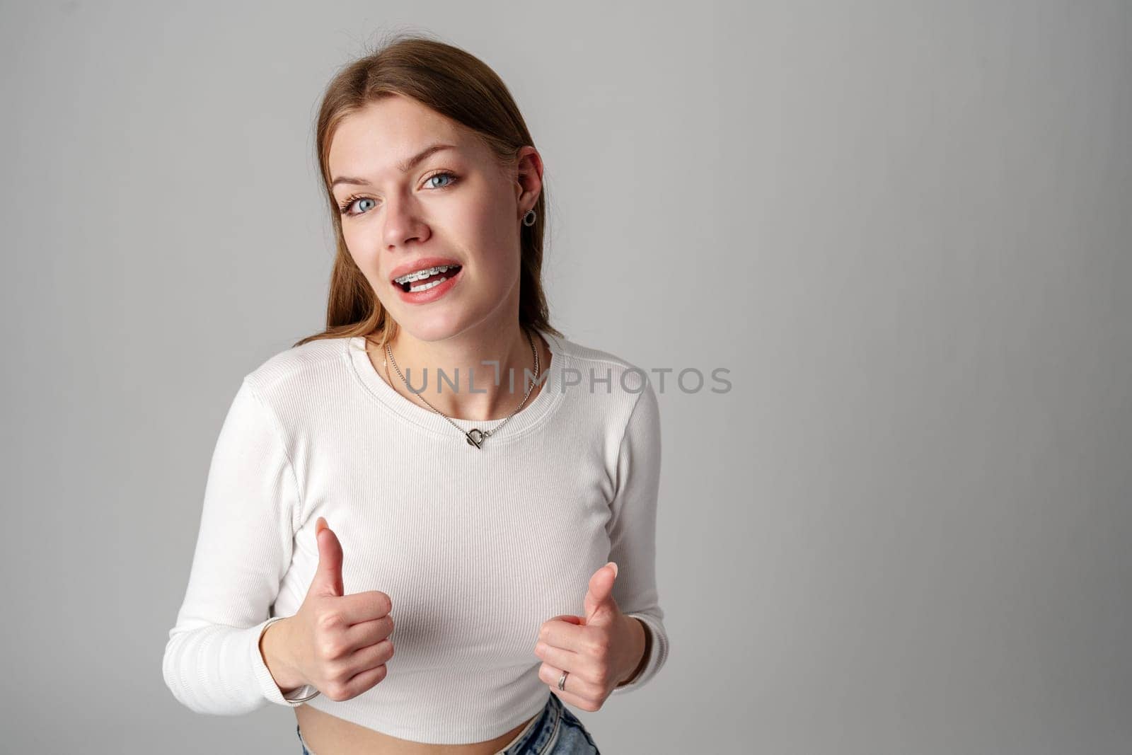 Young Woman Giving Thumbs Up Sign in studio close up