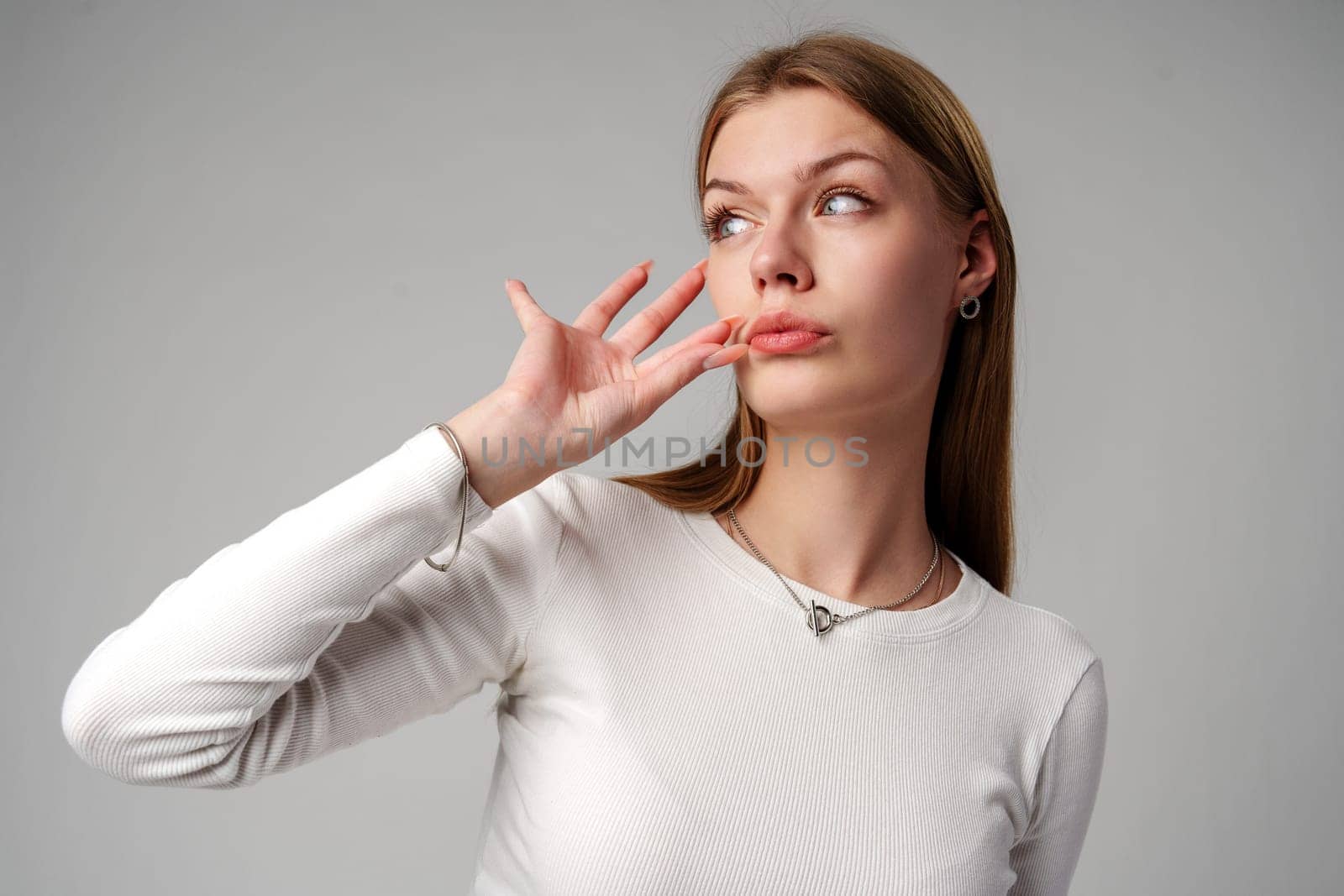 Woman Posing With Finger on Lips Hush Sign in Studio close up