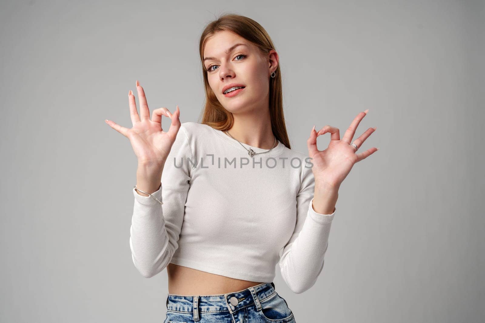 Young Woman Giving Thumbs Up Sign in studio close up