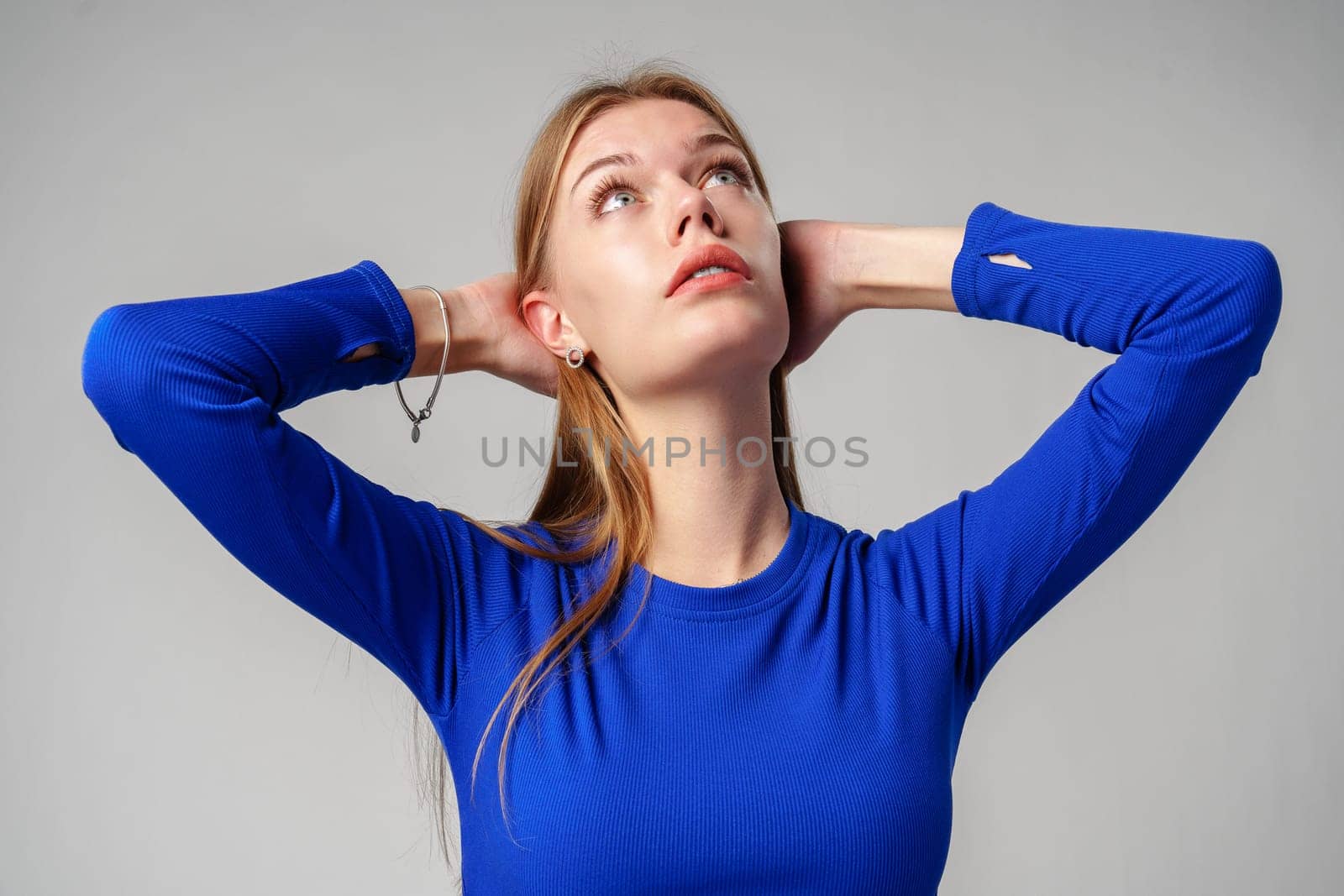 Portrait of Young Woman in Blue Top on gray background close up