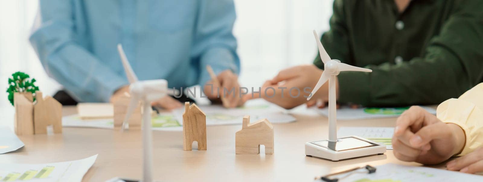 Green business meeting represented renewable energy. Skilled businesspeople discuss green business investment at table with environmental documents. Closeup. Focus on hand. Delineation.