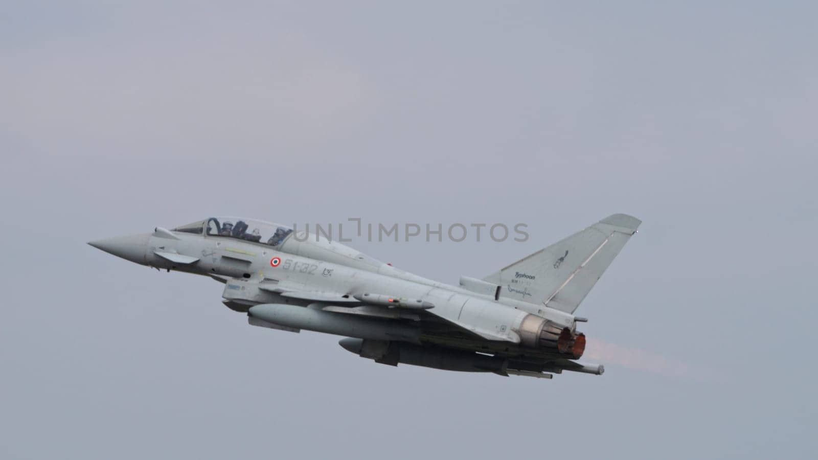Istrana Italy April 5 2024: Combat Aircraft in Flight with Full Afterburner Power in Grey Sky. Eurofighter Typhoon of Italian Air Force. Copy Space.