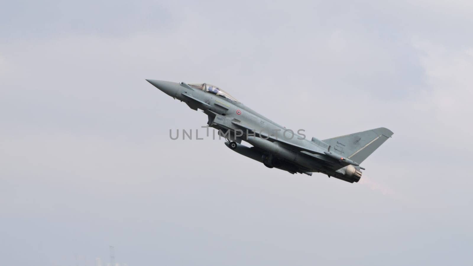 Istrana Italy April 5 2024: Isolated Fighter Jet in Flight in Grey Sky. Side View with Copy Space. Eurofighter Typhoon of Italian Air Force.