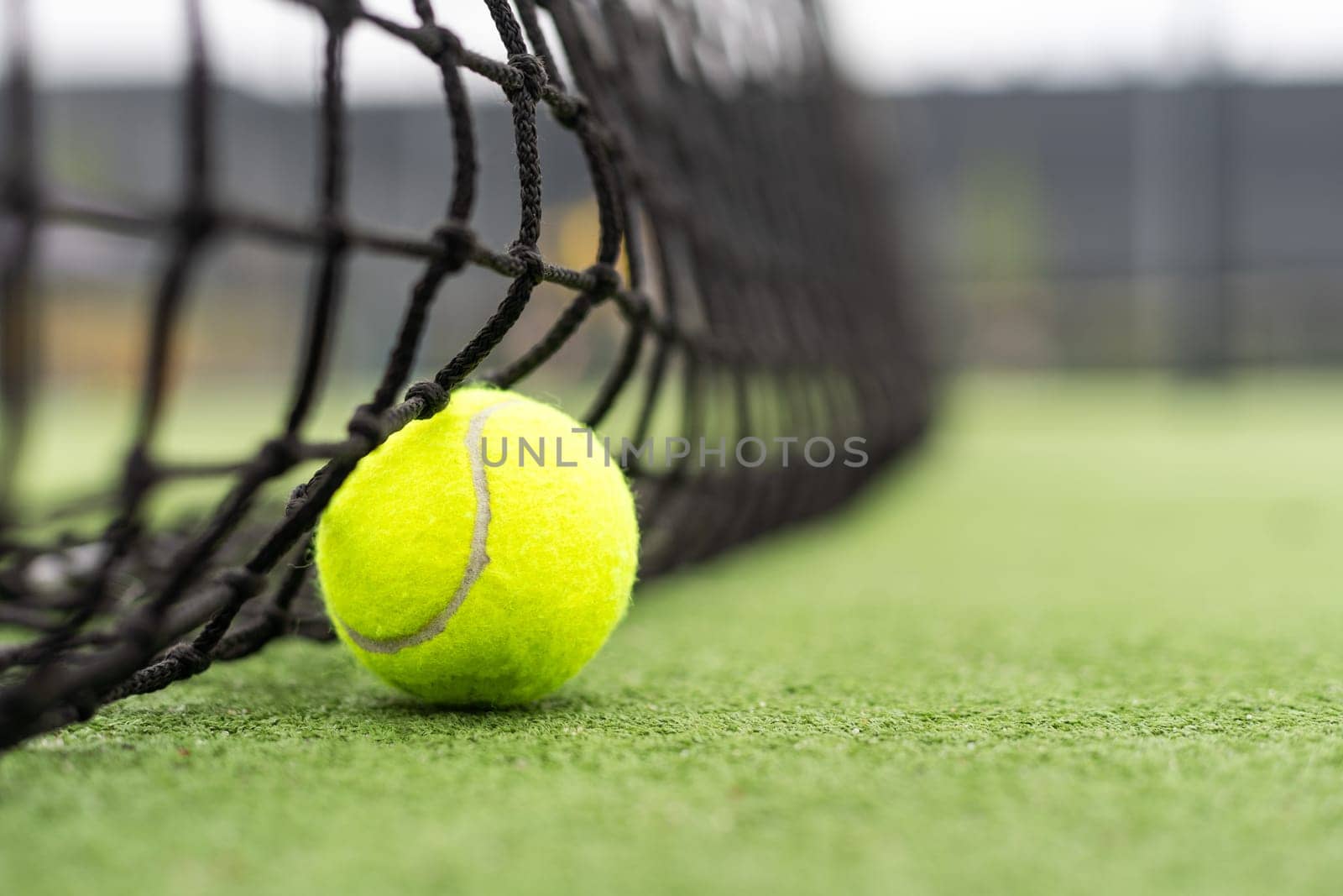 Tennis Ball on the Court against the Court Net. High quality photo