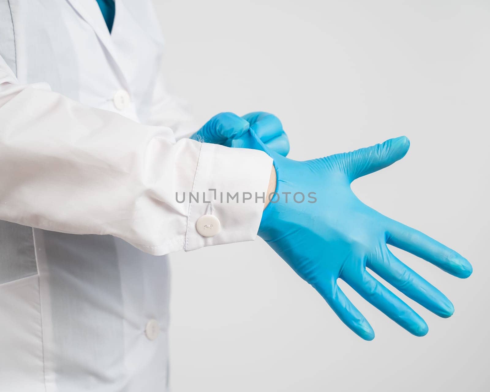 The doctor puts on latex gloves on a white background. by mrwed54