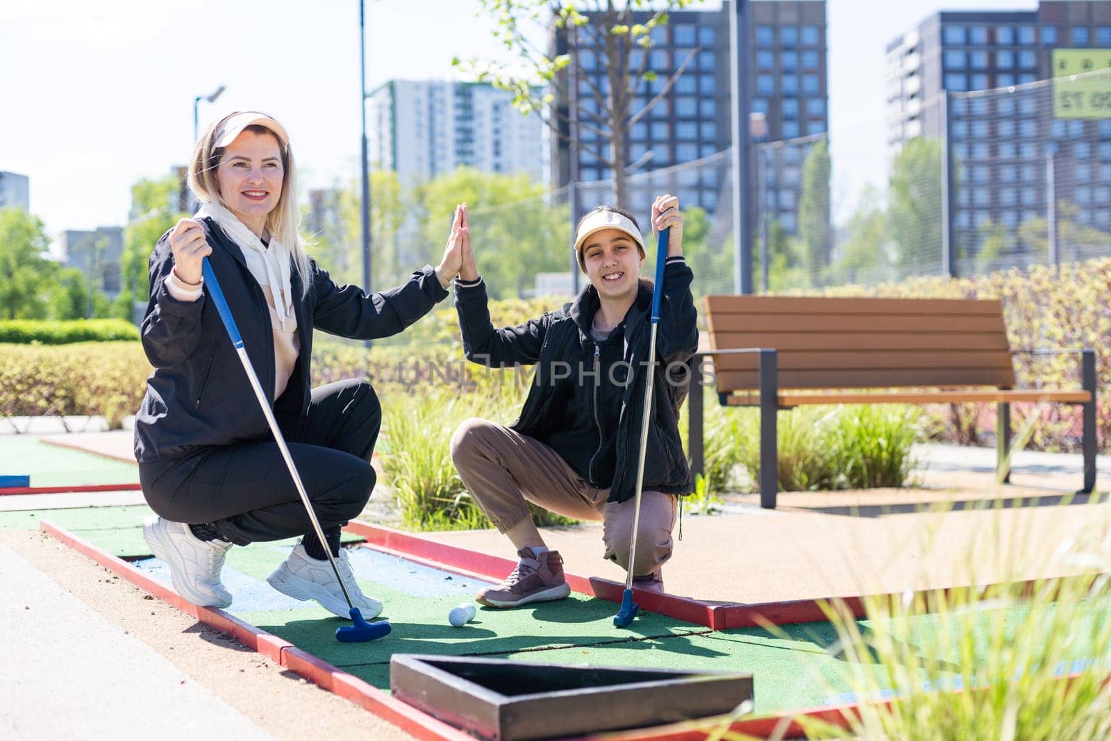 little girl and mother playing mini golf. High quality photo