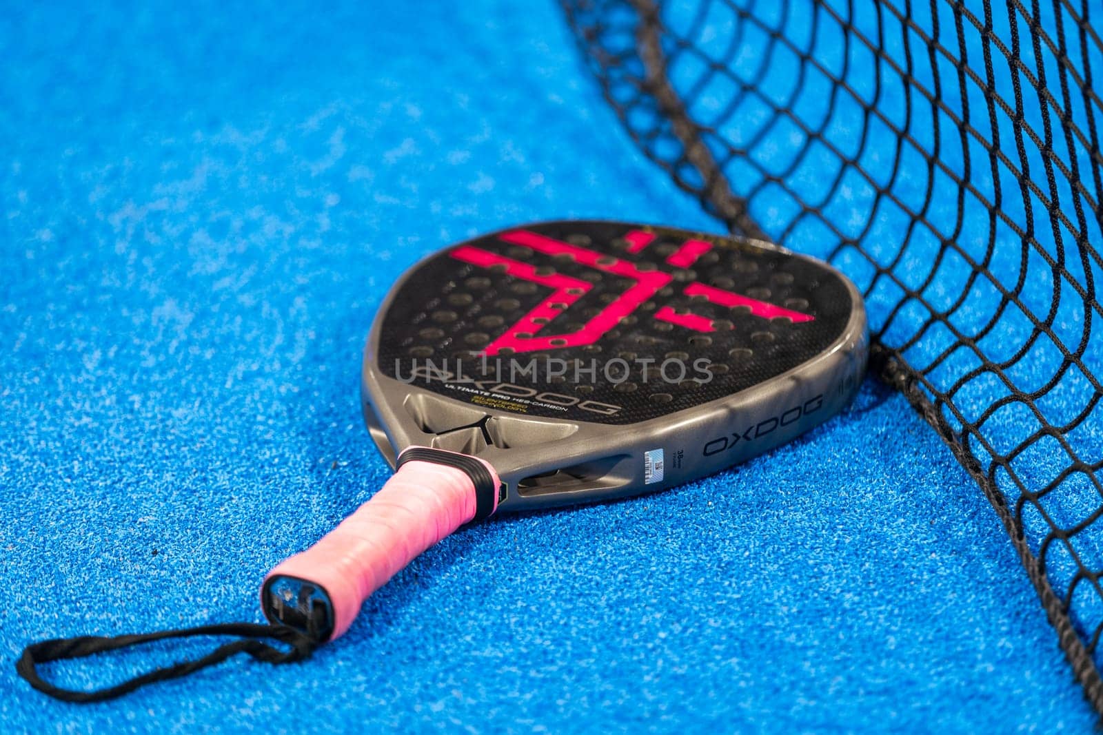 Kyiv, Ukraine, April 18, 2024. Black professional paddle tennis racket and ball with natural lighting on blue background. Horizontal sport theme poster, greeting cards, headers, website and app. High quality photo