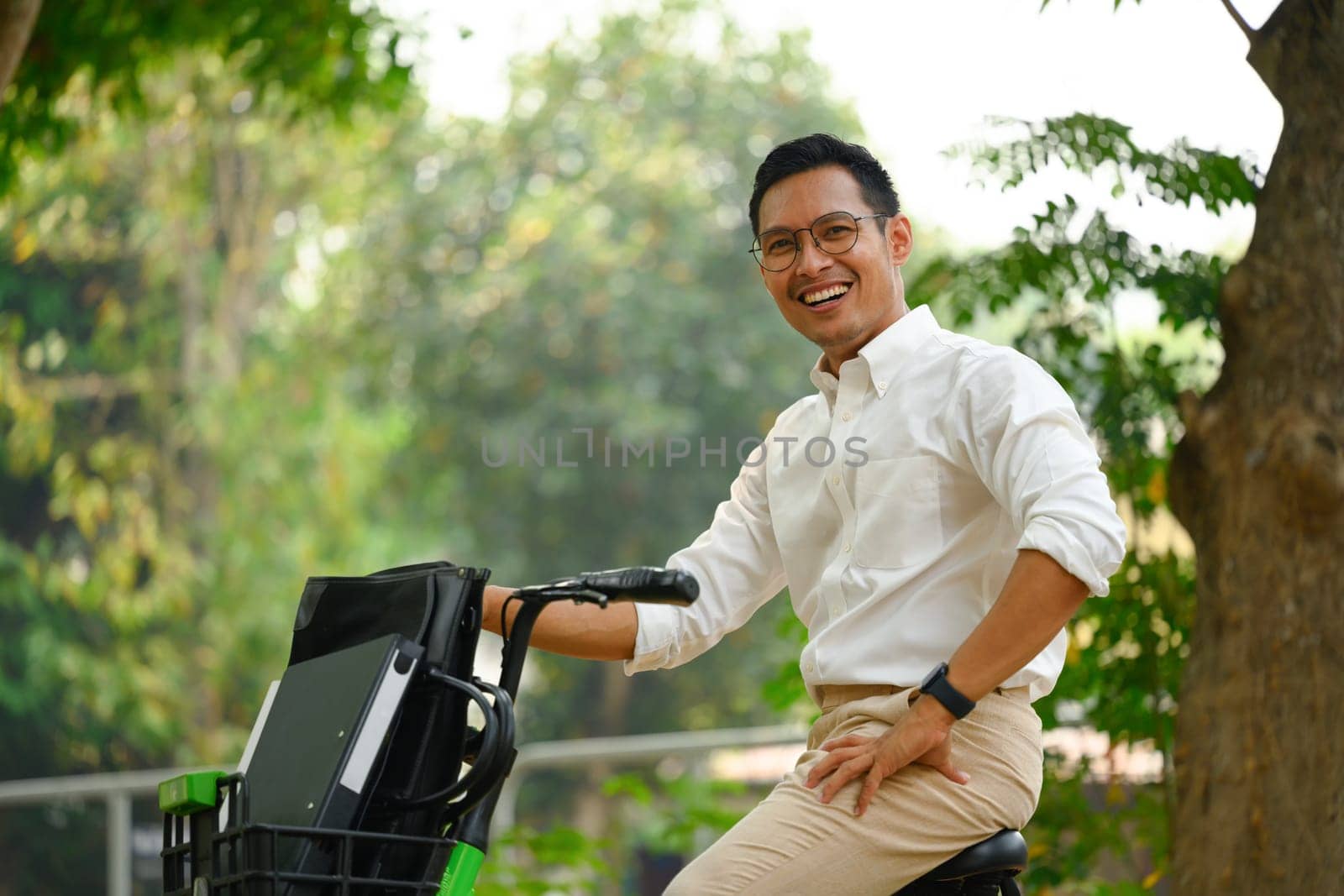 Active businessman commuter traveling to work with electric bicycle in the city.