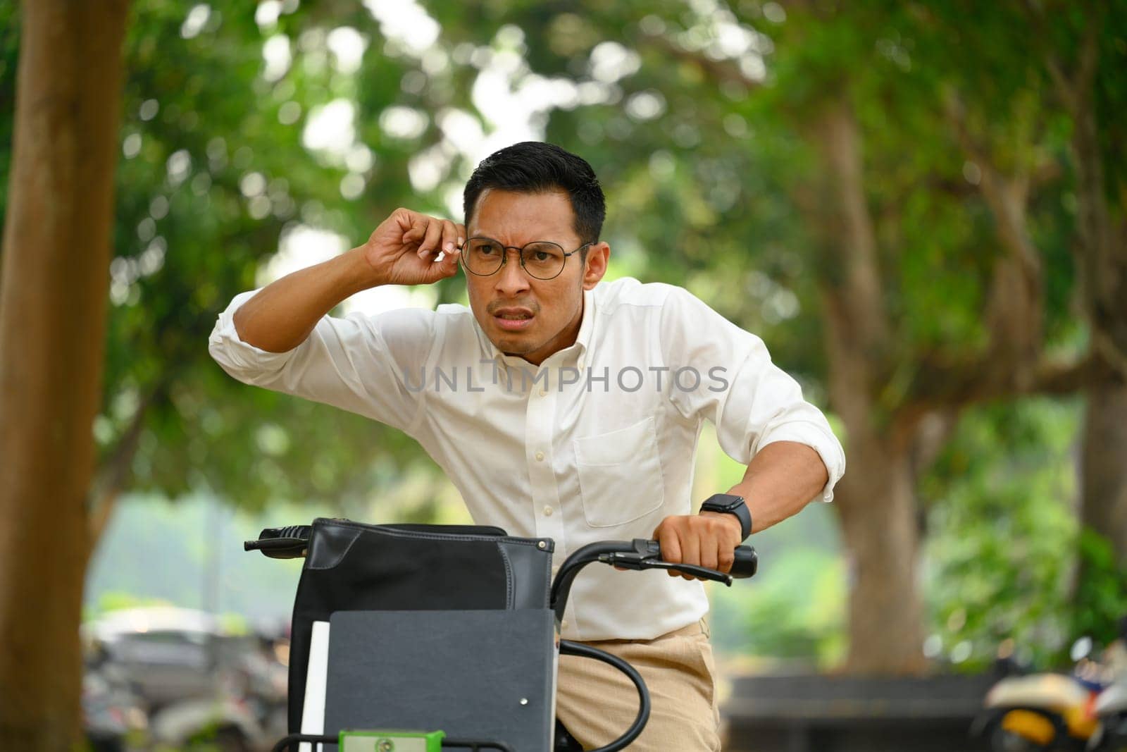 Shot o man office worker riding a bike and hurrying up at work by prathanchorruangsak