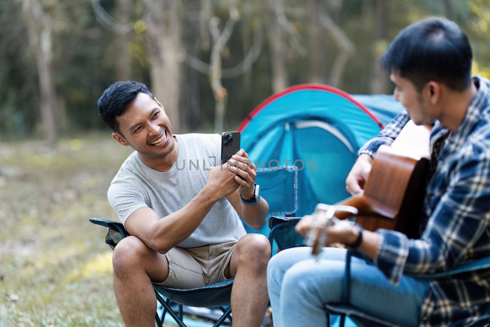 LGBTQIA Gay couple camping together in woods for holidays and relax together at the weekend by itchaznong