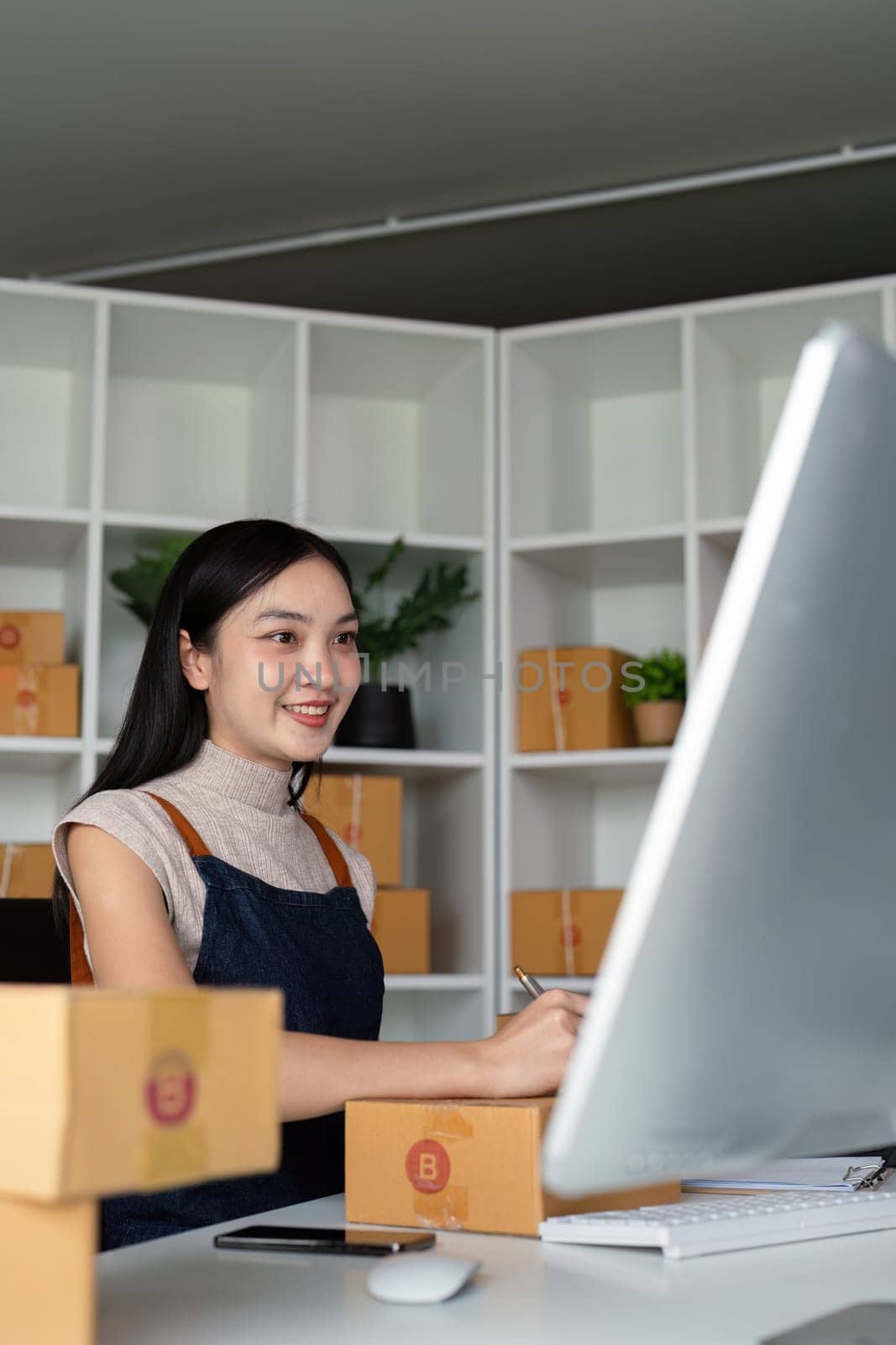 Woman asian in an online store check the customer address and package information on the laptop. Online shopping concept.