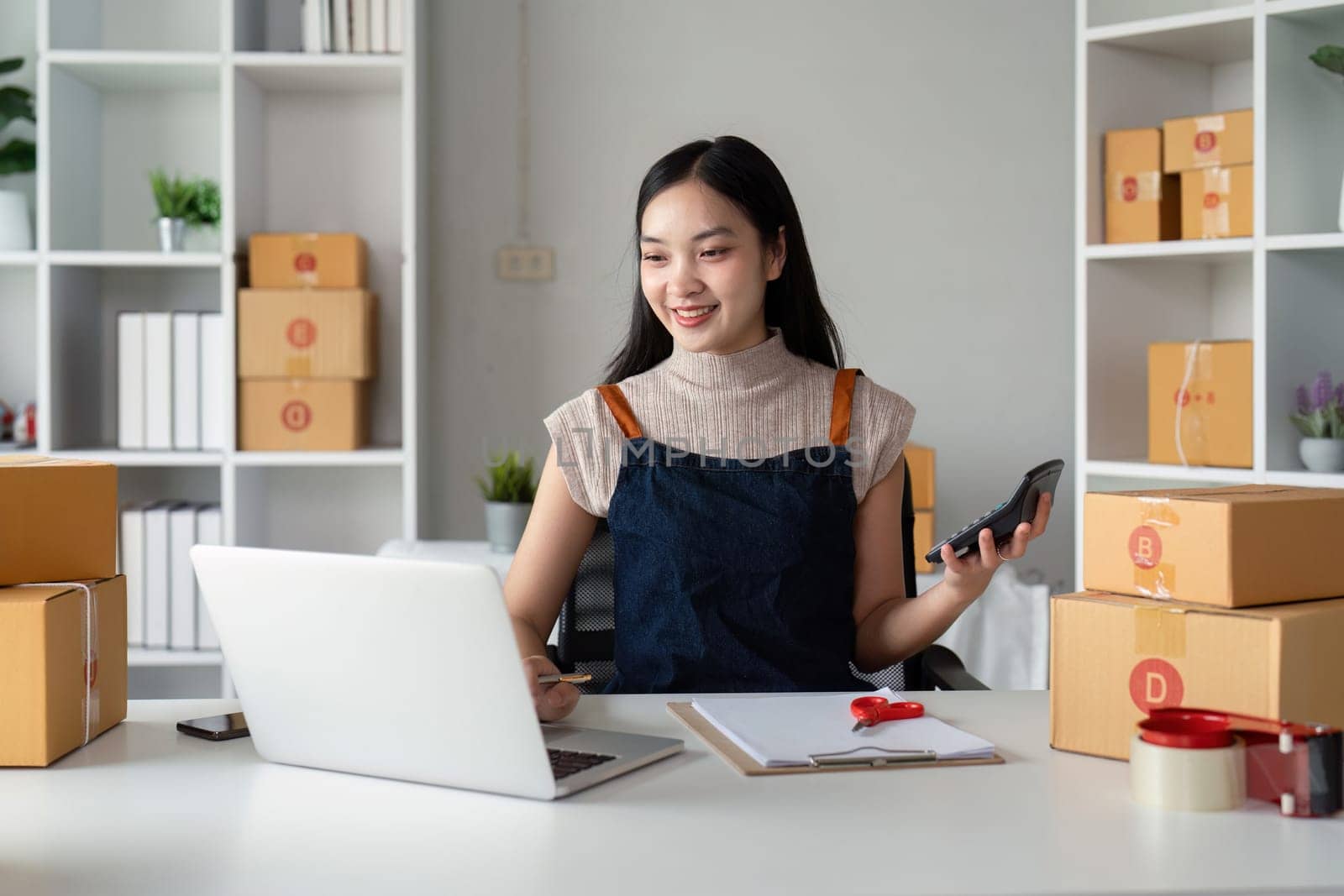 Woman asian in an online store check the customer address and package information on the laptop. Online shopping concept.