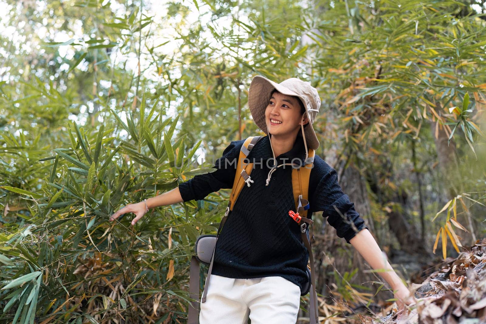 LGBT gay woman with backpack walk along forest path while hiking and camping on the weekend by itchaznong