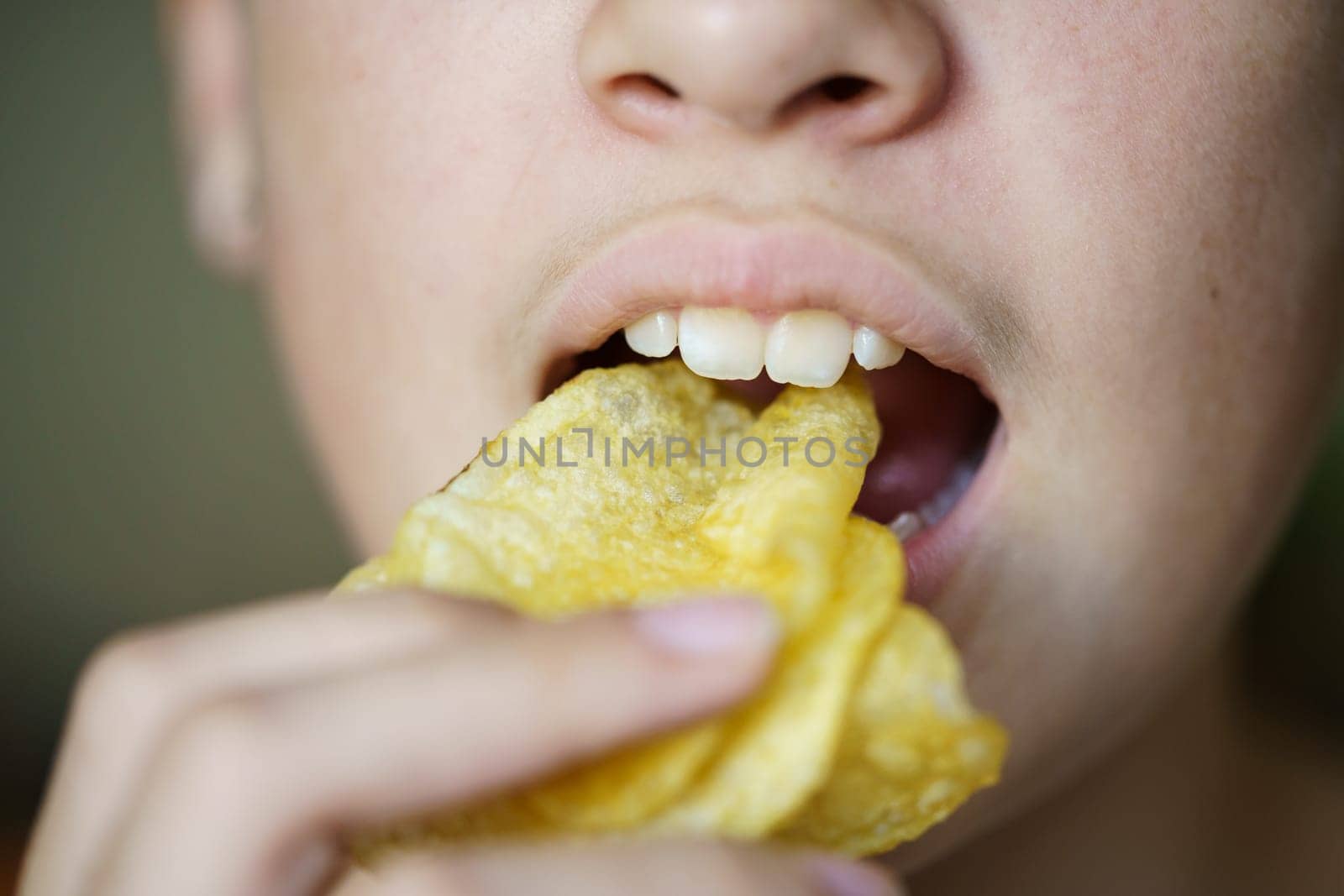 Crop unrecognizable girl eating crunchy potato chips by javiindy