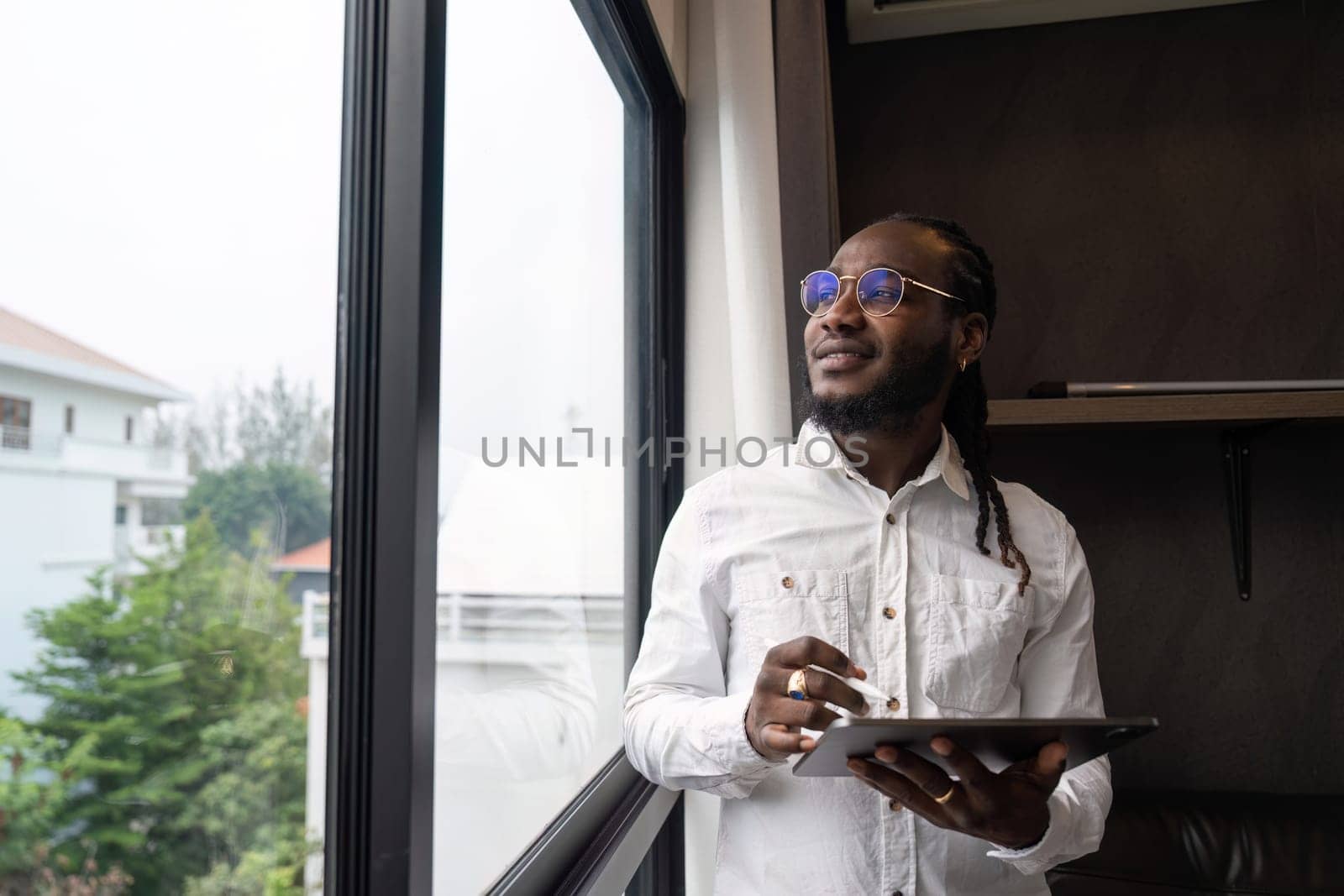 Happy African man using tablet at home living room.