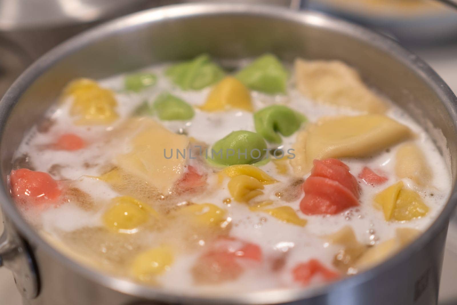 In a pot, colorful dumplings are being boiled. Preparing lunch or dinner by AnatoliiFoto