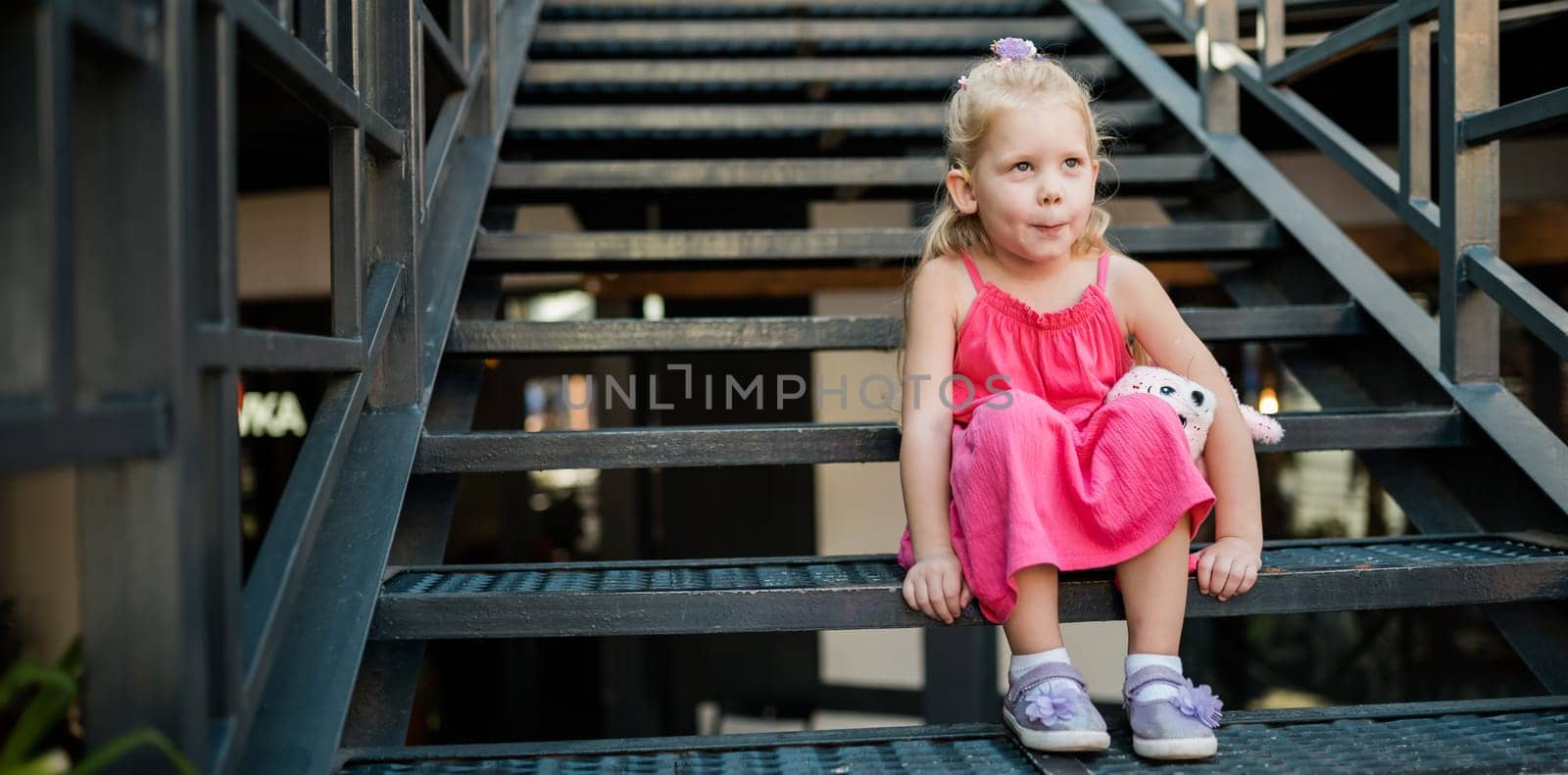 Banner child with hearing problem and cochlear implant plays in street, deaf kid began to hear. Hearing loss in childhood and treatment concept. Inclusion and disability. Copy space and empty place for text. by Satura86