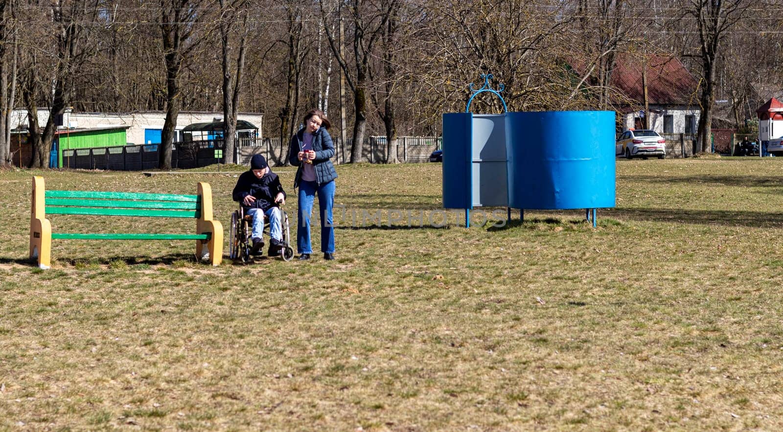 Brest, Belarus - 03.03.2024 - Mother with her handicapped teenager son out for walk in the park