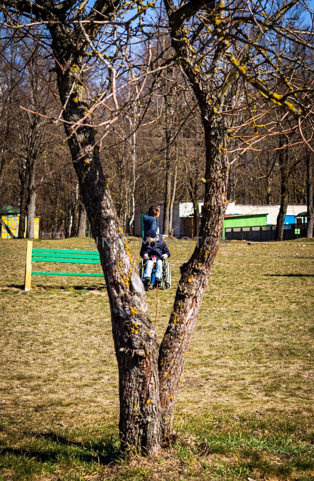 Brest, Belarus - 03.03.2024 - Mother with her handicapped teenager son out for walk in the park