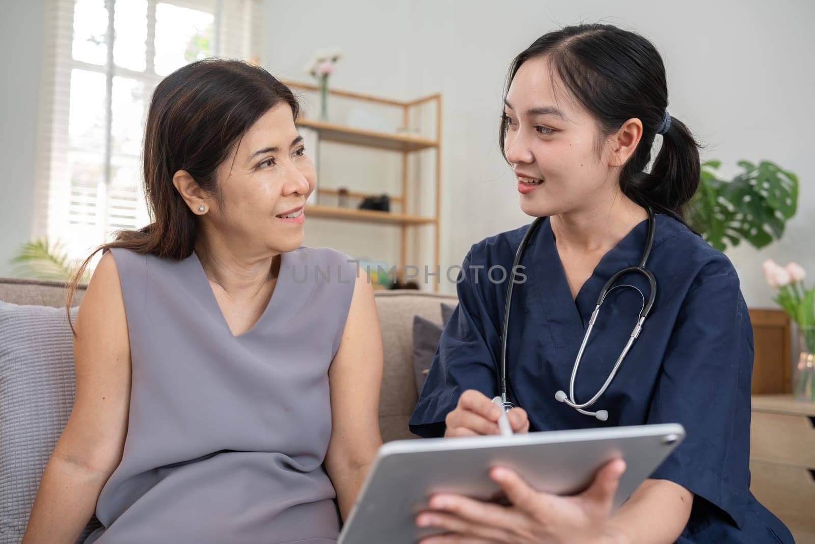 A young woman who takes care of the sick sits and gives advice to a retired woman about health care and the use of tonics.