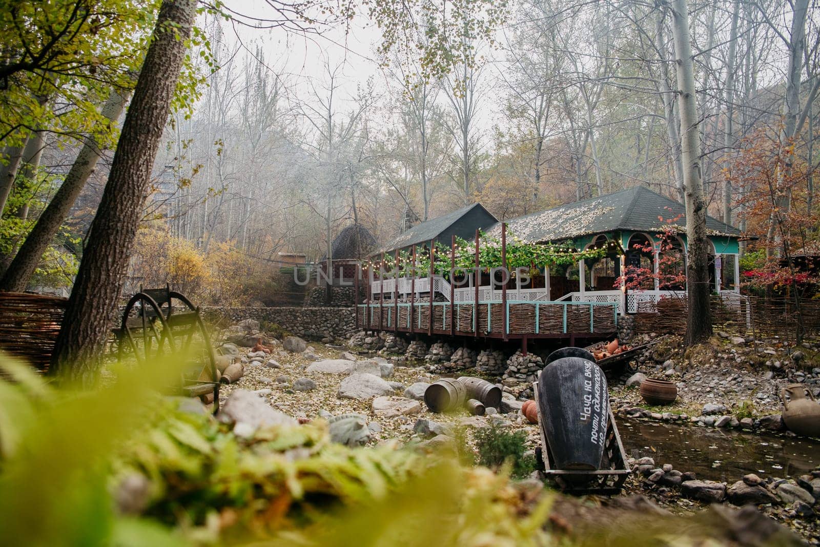 Secluded cabin by river in fall woods. Ideal for peaceful retreat or romantic getaway amidst vibrant foliage and lush trees.