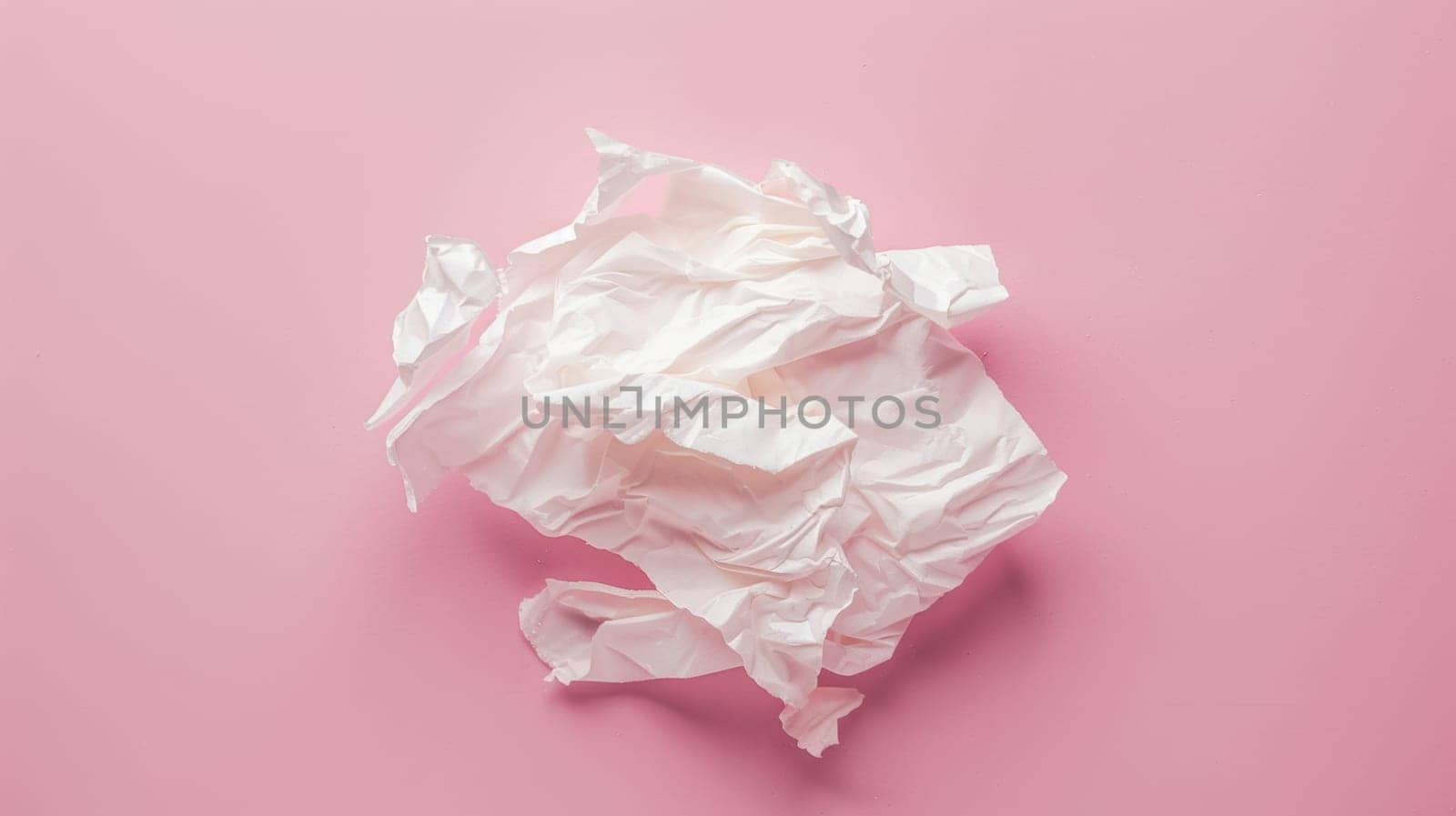 Crumpled paper on pink background.