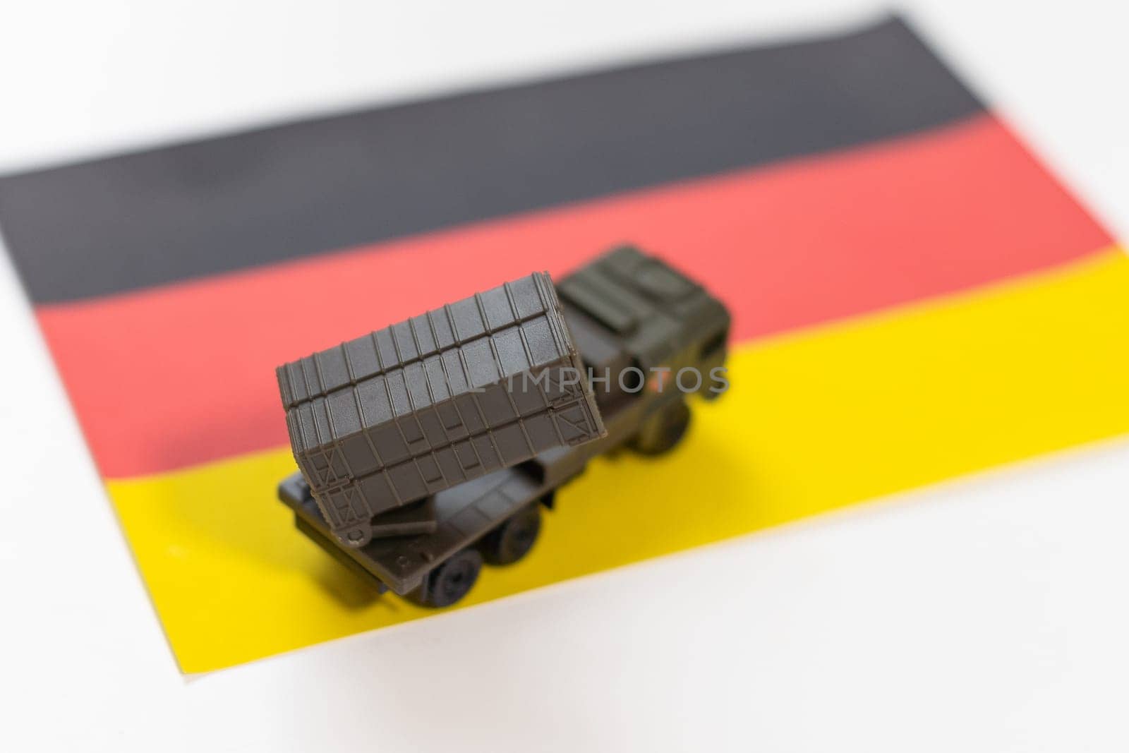 War, military threat, military power concept. Germany. Tanks toy near German flag on black background top view. High quality photo
