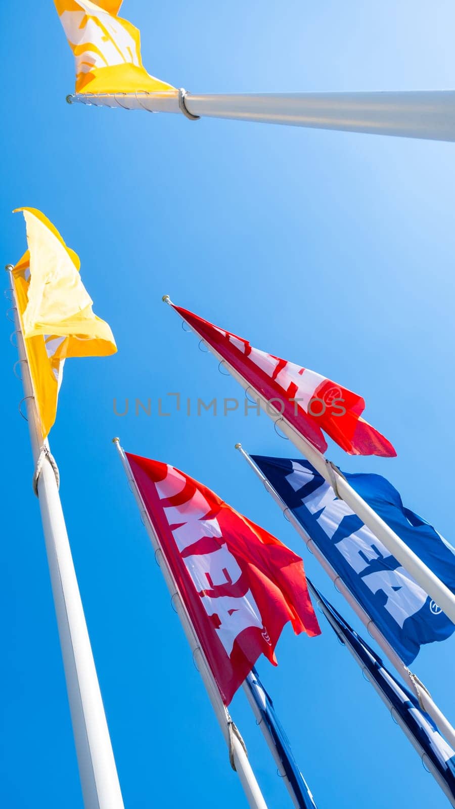 PRAGUE, CZECHIA -APRIL, 2024: Red, blue and yellow IKEA flags against blue sky.