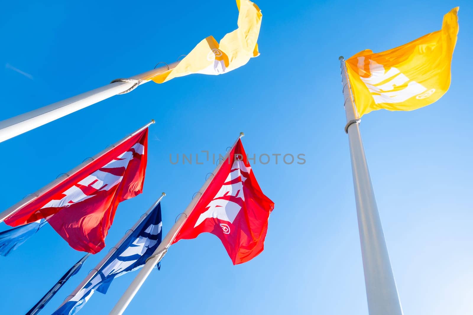Yellow, red and yellow IKEA flags against blue sky by vladimka