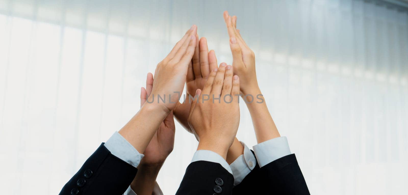 Office worker team stacking hand together symbolize successful group of business partnership and strong collective unity teamwork in community workplace in panoramic banner. Shrewd