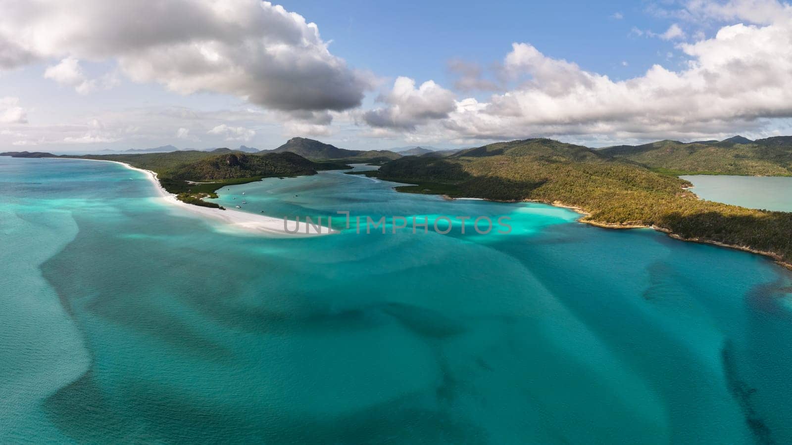 Aerial photo of the iconic Hill Inlet near Whitehaven beach on the Whitsundays, Queensland. Shot from above, gorgeous shades of aqua, blue and green mix from the silicone white sand and beach.