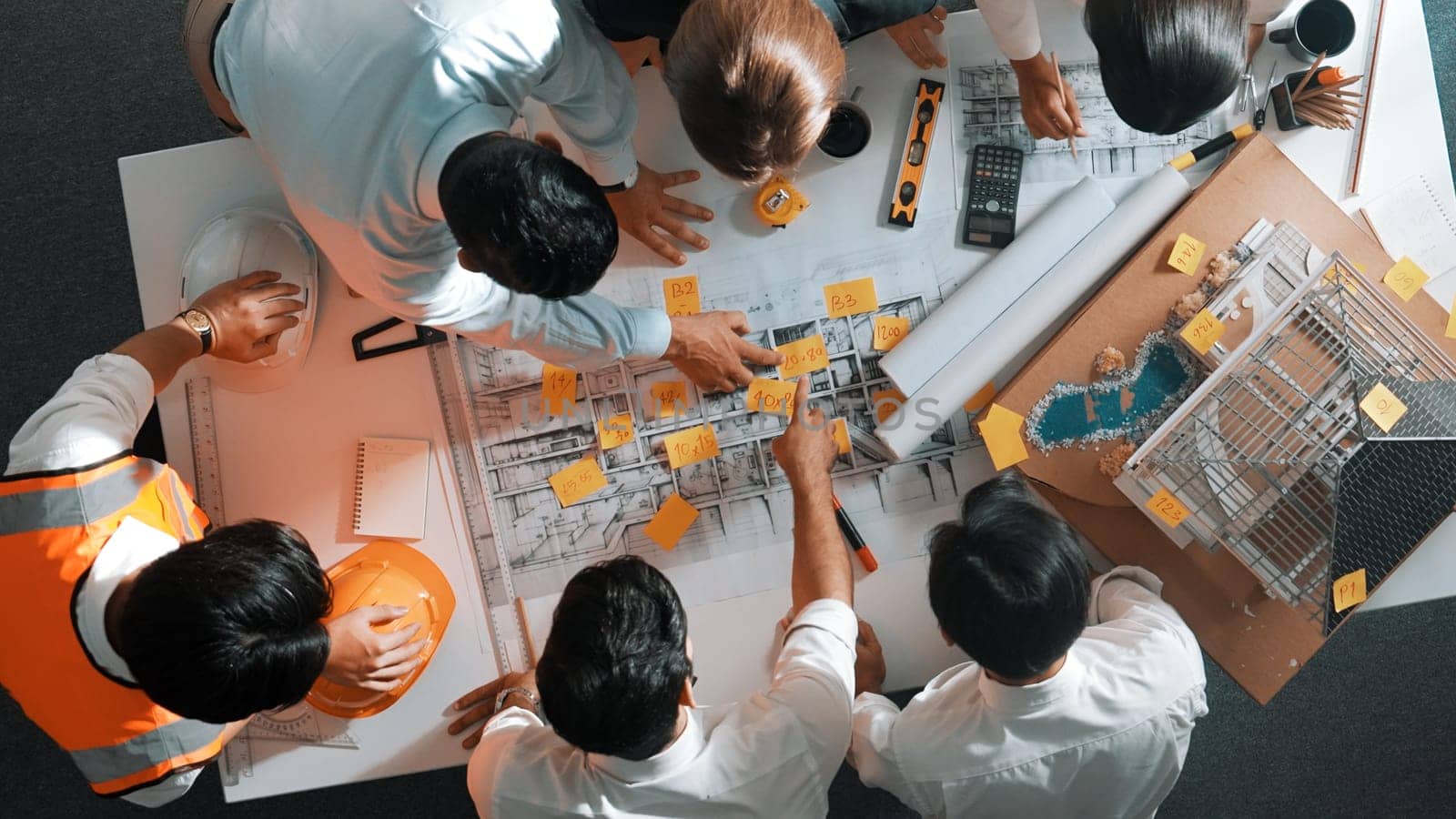 Top down view of skilled engineer team talking while looking at project plan. Aerial view of group of smart interior designer working together and planning for engineering construction. Alimentation.