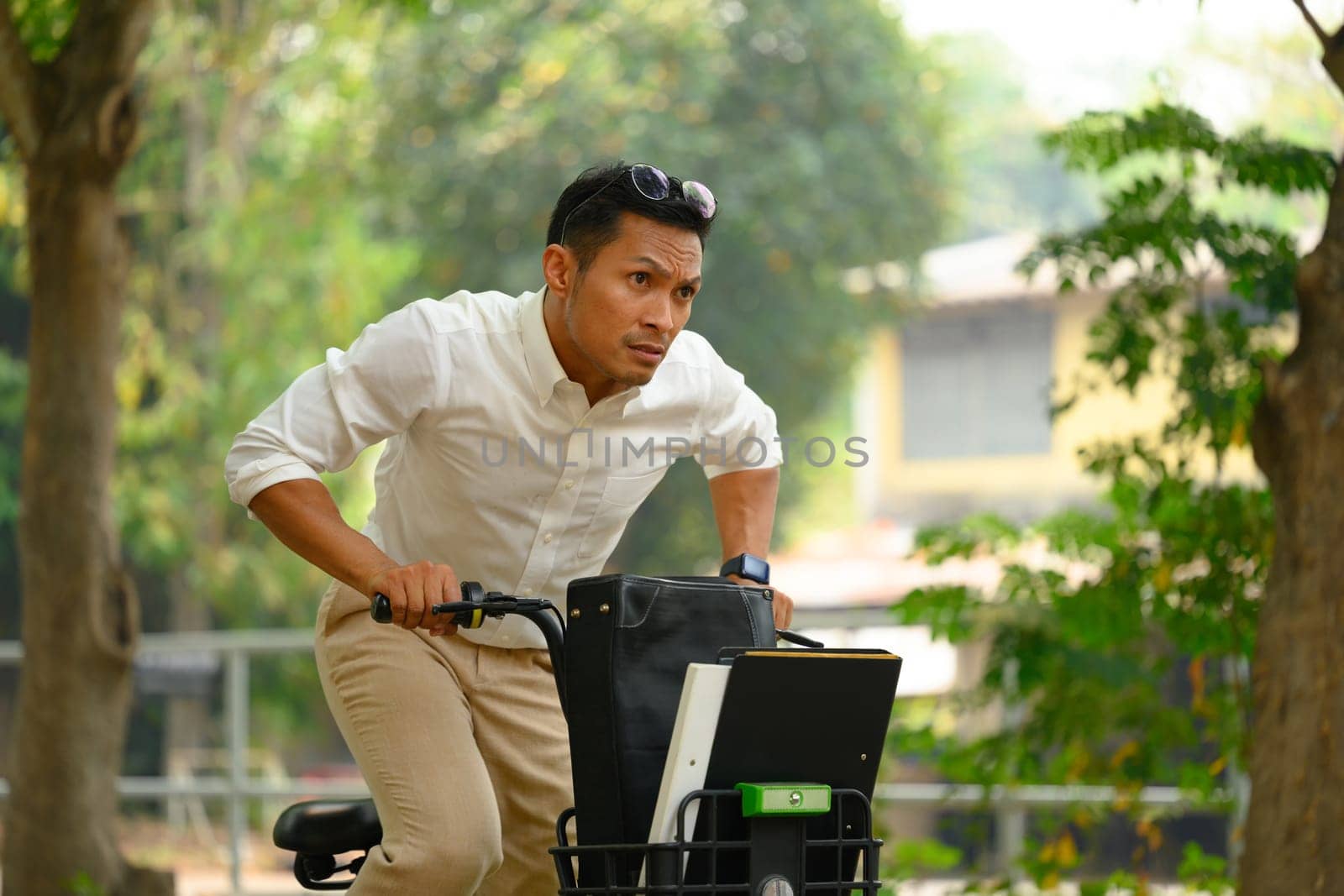 Businessman commuting riding bicycle go to work during the morning rush by prathanchorruangsak