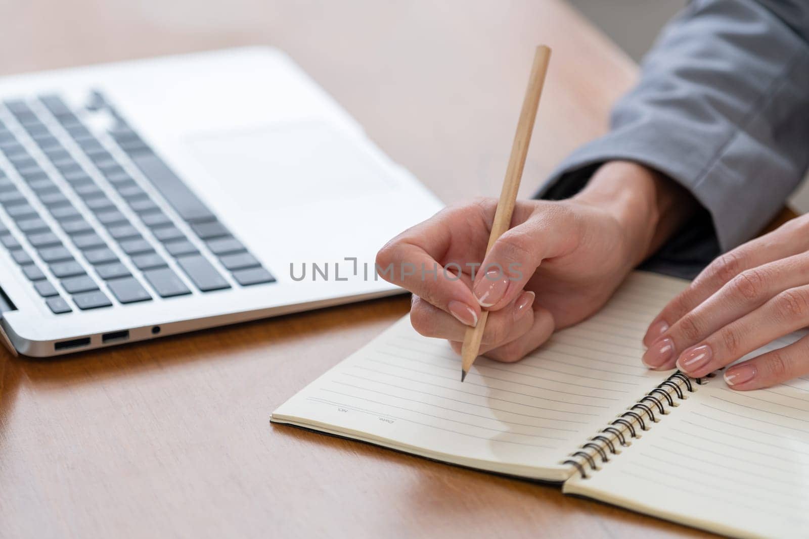 Businesswoman taking note while working on business on workspace table. Young college student study writing or brainstorming strategic plan in office workplace for business success. Blithe