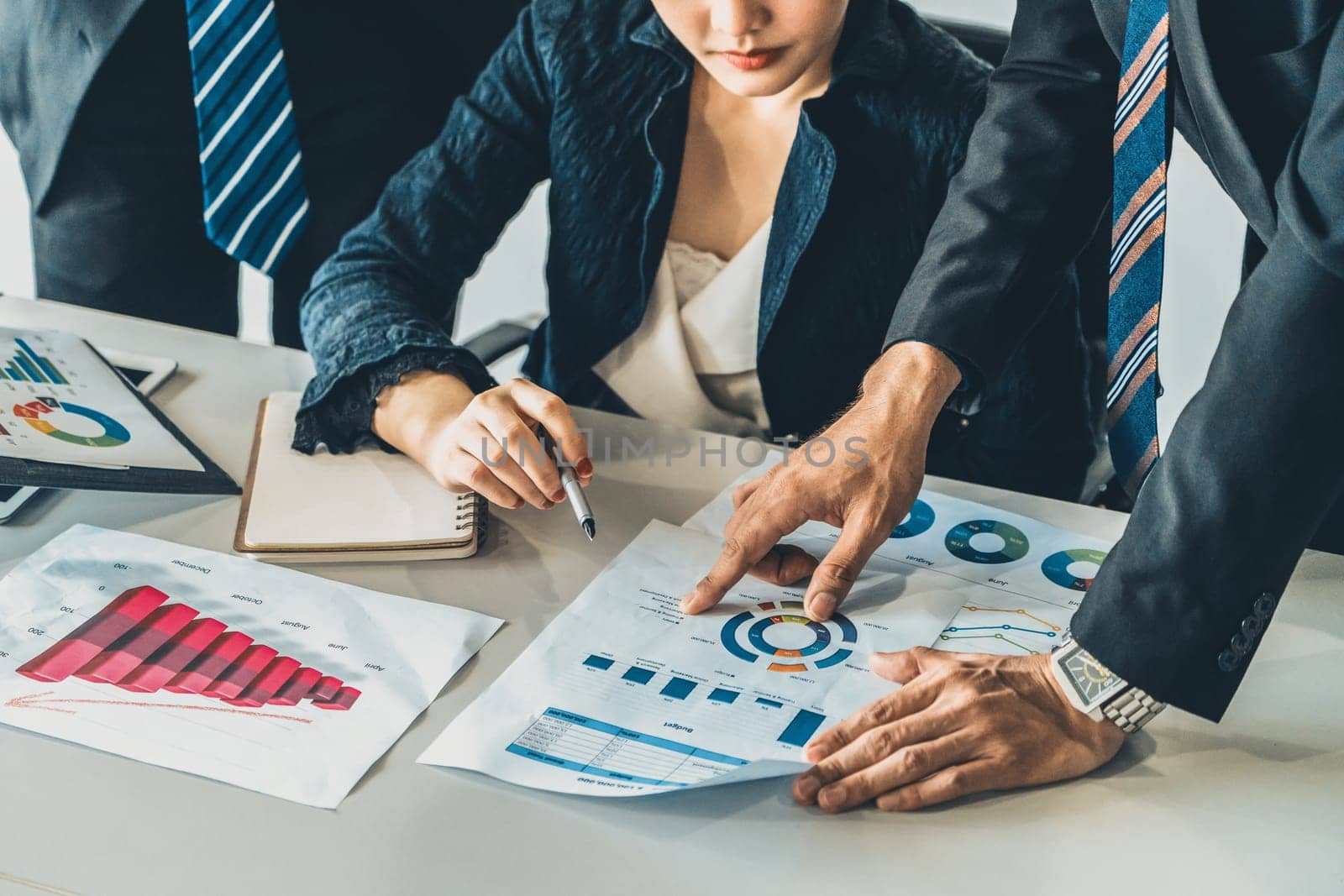 Businessman and businesswoman in meeting working with many financial statement document on desk. Concept of busy business profit analysis and brainstorm. Close up shot at people hands and papers. uds