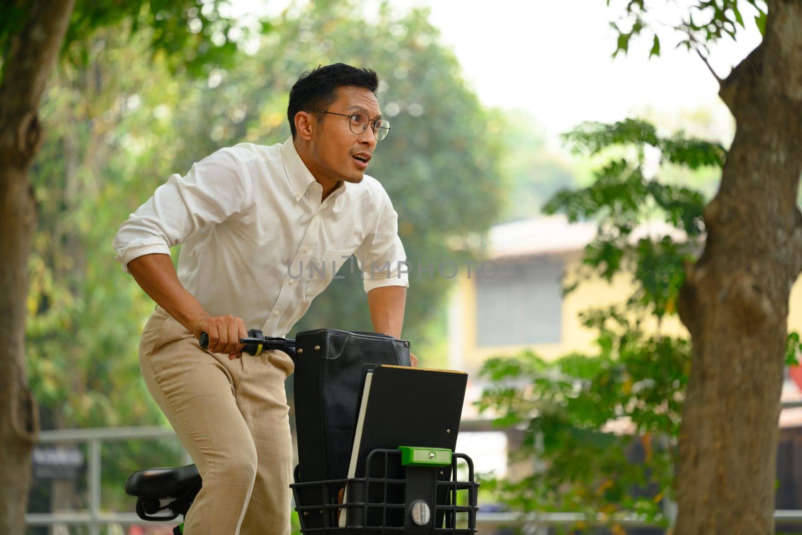 Active businessman commuting riding bicycle go to work during the morning rush.