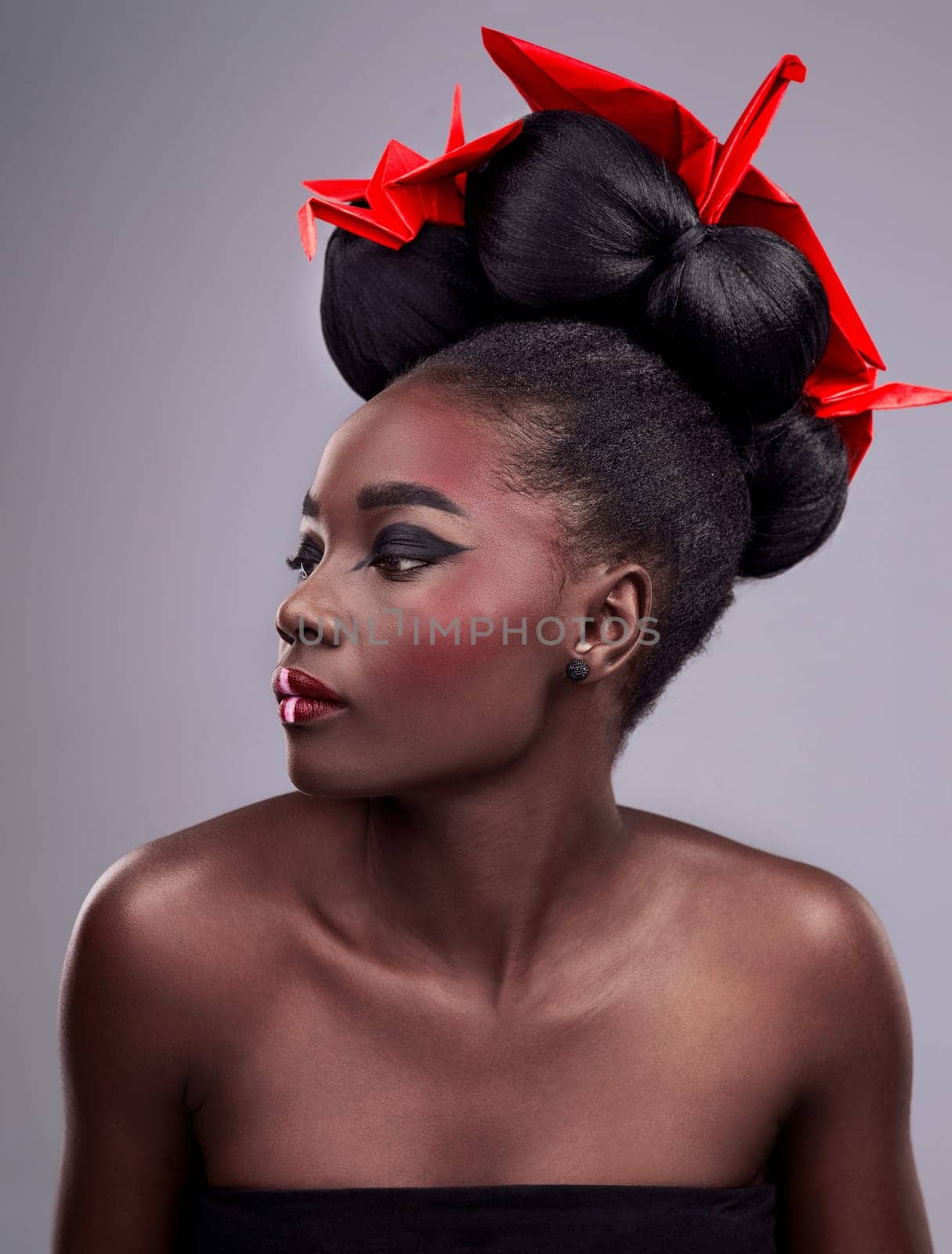 Black woman, makeup and cosmetics with creativity, origami and shine on grey studio background. African person, model and girl with cosmetics, glow and paper with thinking, artistic and culture by YuriArcurs