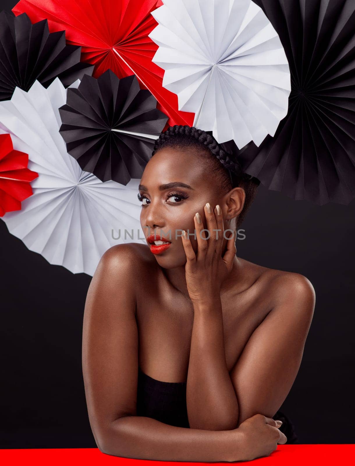 Woman, portrait and beauty with origami fans in studio isolated on a dark background. Face, makeup cosmetics and skincare of black female model with traditional craft paper art for geisha headwear.