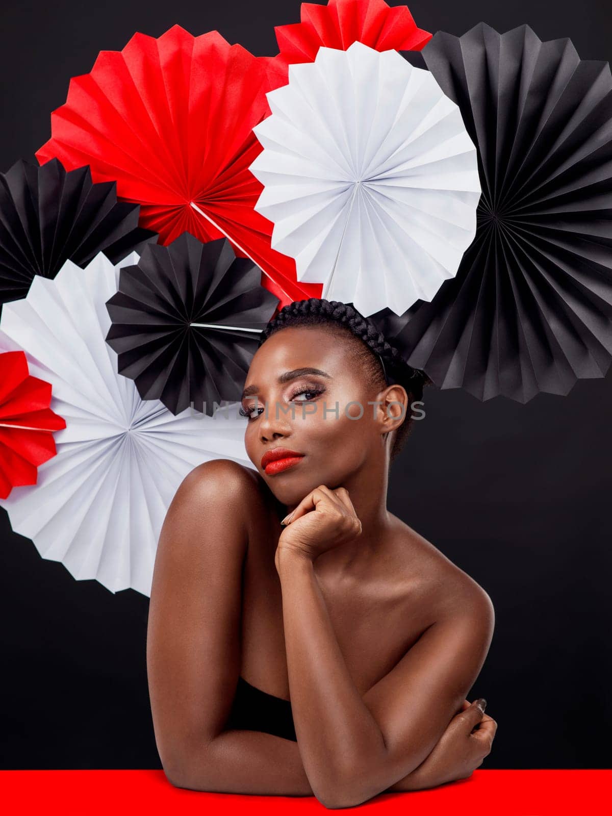 Woman, portrait and beauty with origami fans in studio isolated on a dark background. Face, makeup cosmetics and skincare of black female model with traditional, culture and paper art for geisha.