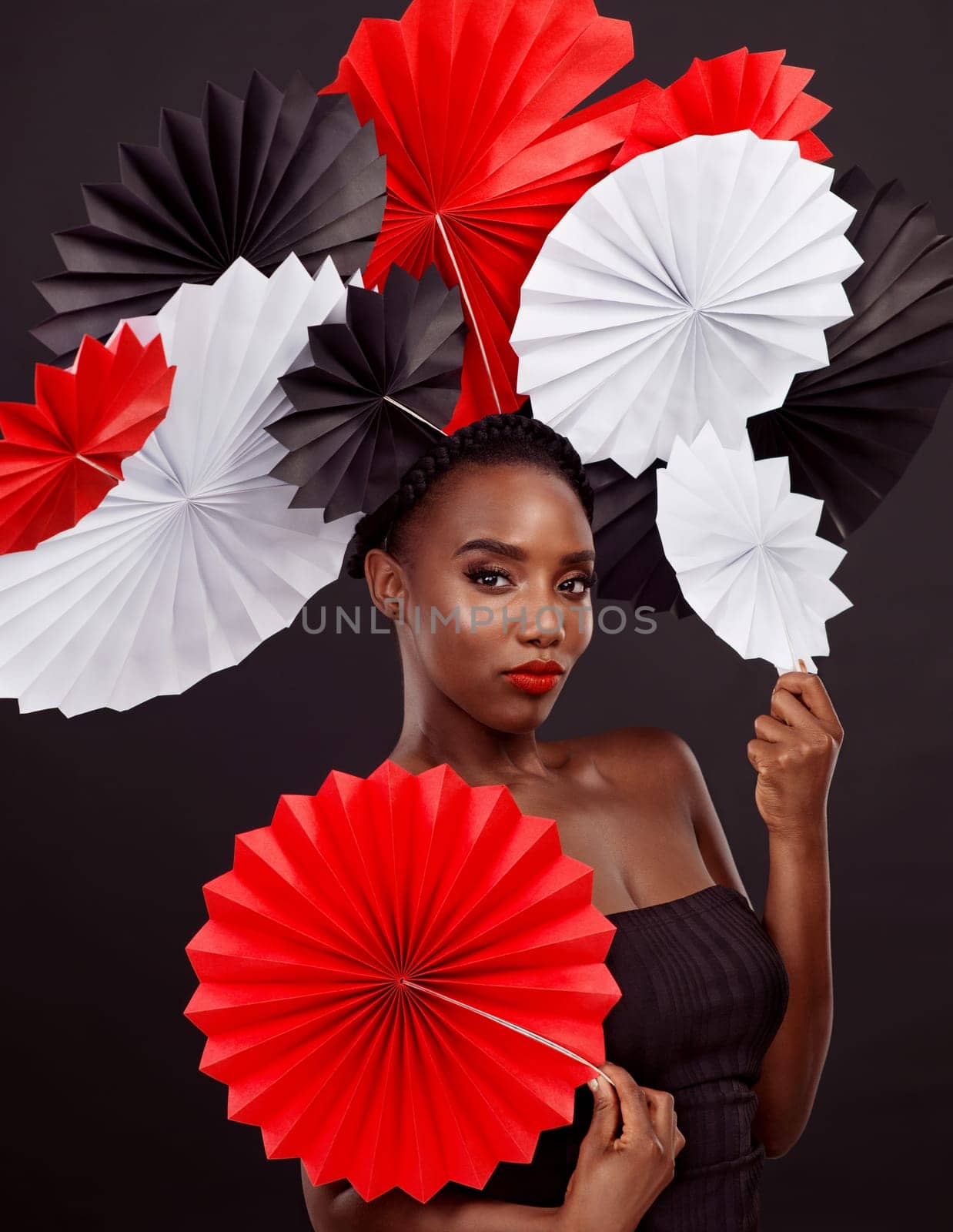 Origami fans, black woman and portrait in studio for beauty with makeup isolated on dark background. Cosmetics, pride and oriental paper art for culture with tradition, confidence and skincare. by YuriArcurs