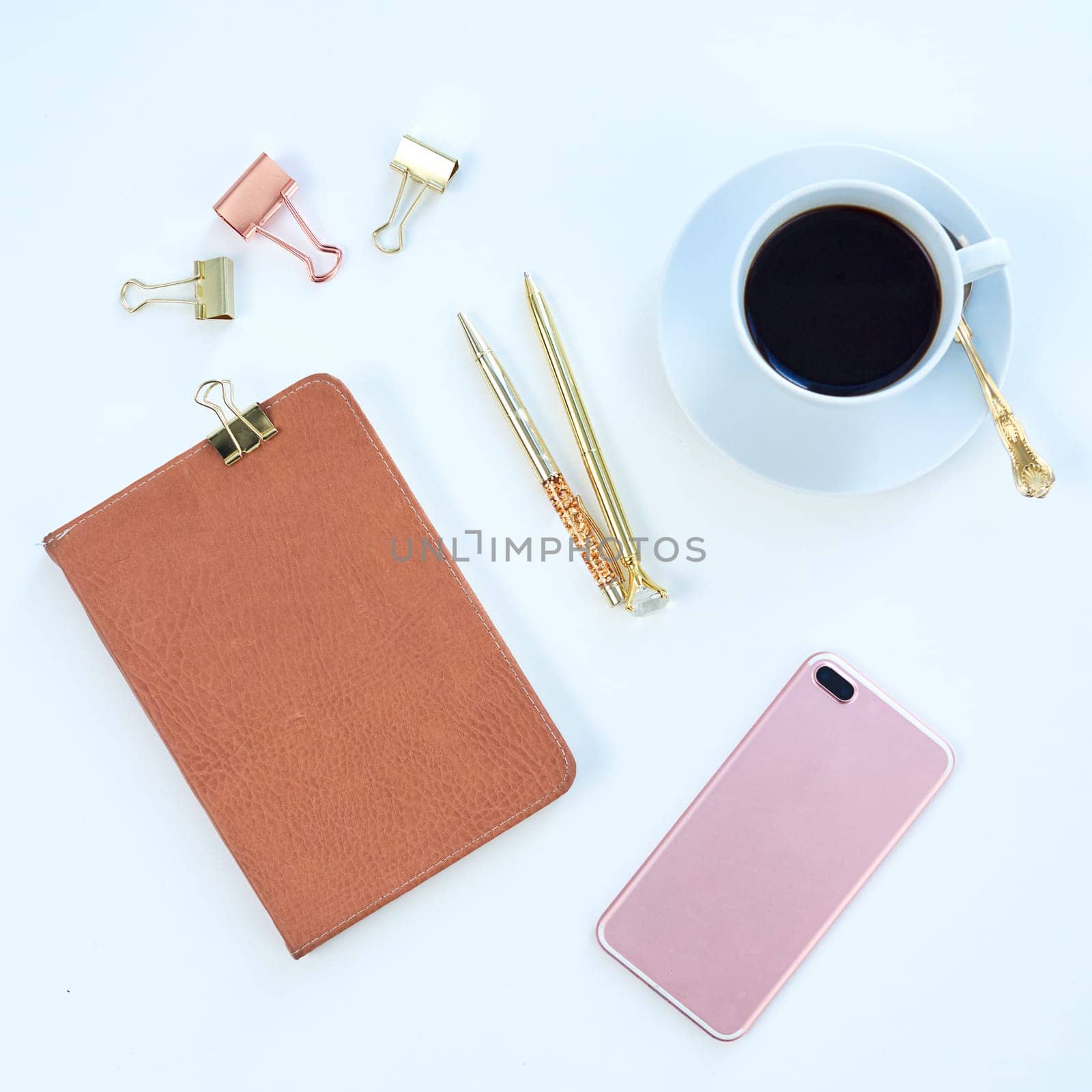 Above of notebook, phone and coffee in studio for working, writing notes and planning for career. Creative desk, business and diary, smartphone and stationery for social media on blue background.
