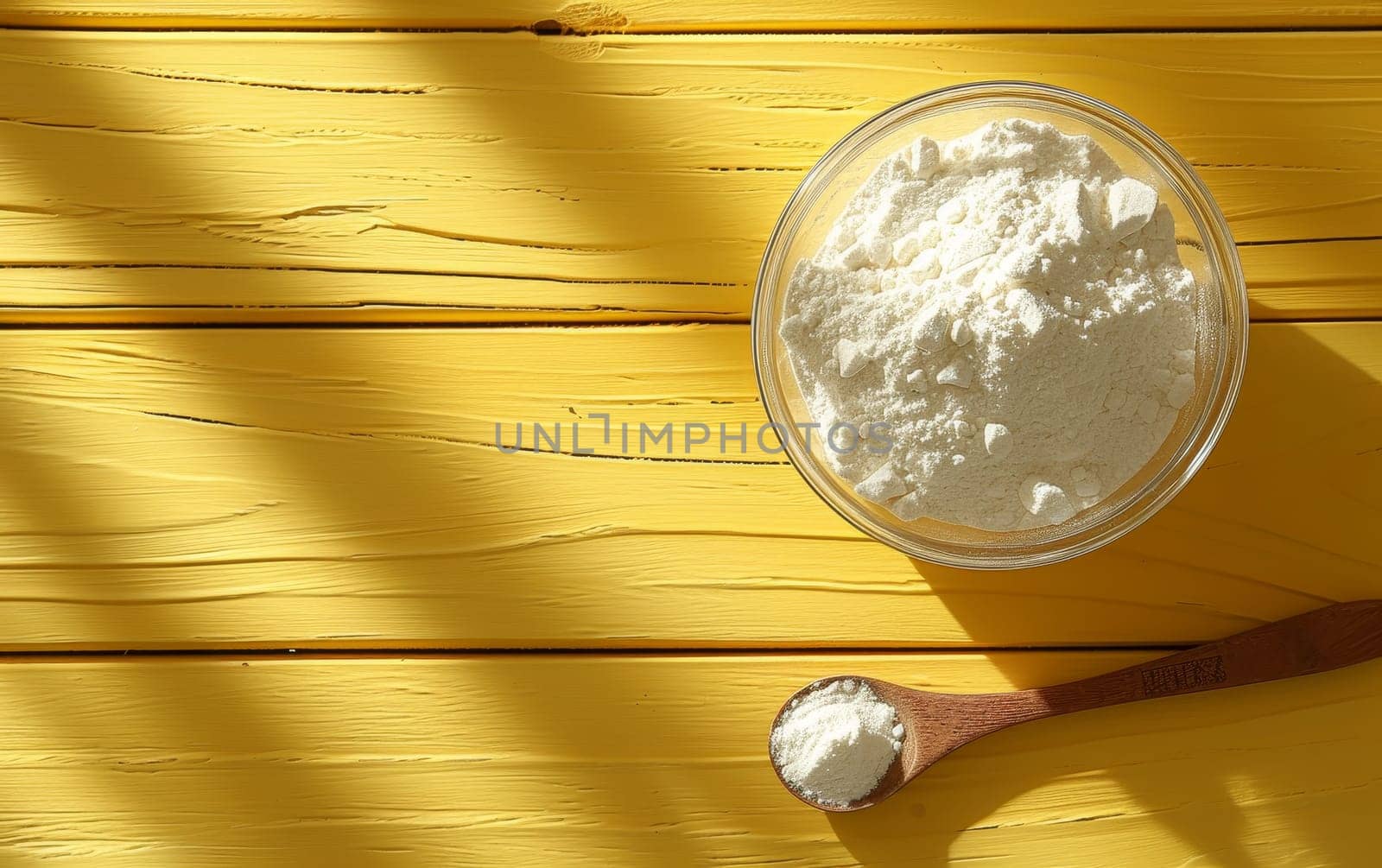 Hydrolyzed collagen powder in a bowl and a spoon on a wooden yellow background with copy space