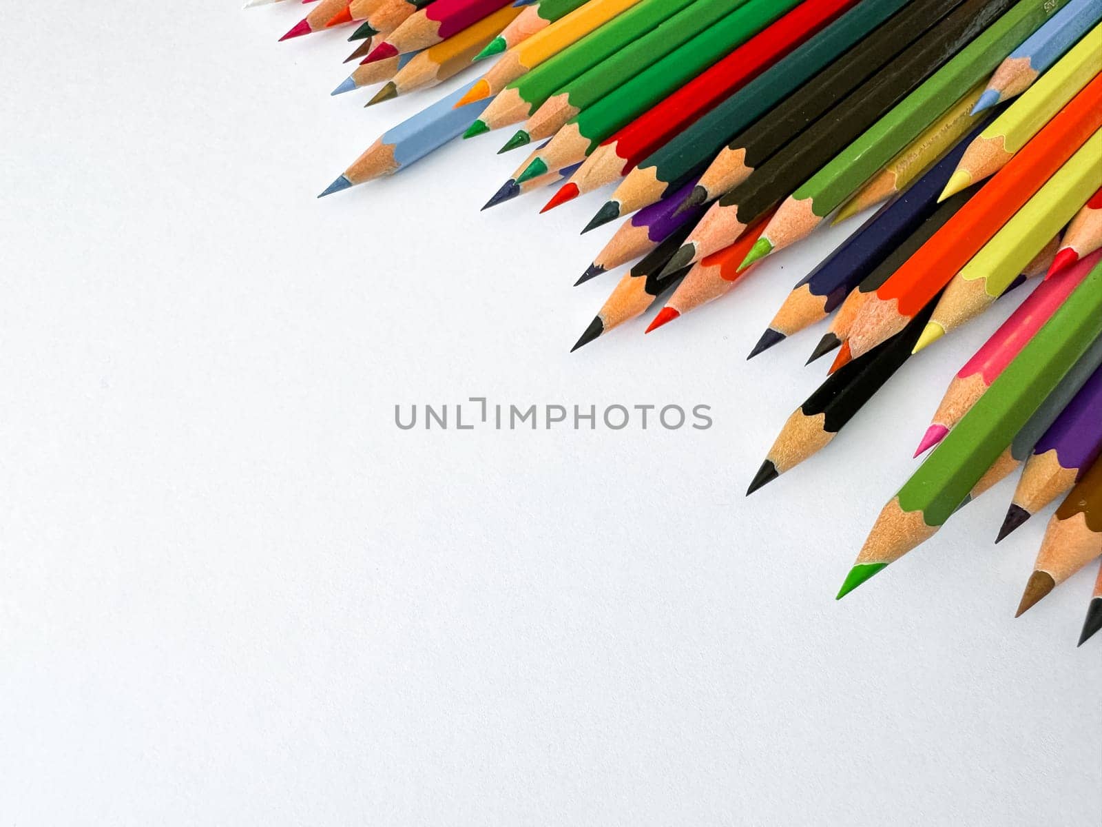 Diagonal arrangement of sharp multi colored pencils on white background with empty space for text. Artistic concept for stationery, education, design advertising banner for school products. by Lunnica