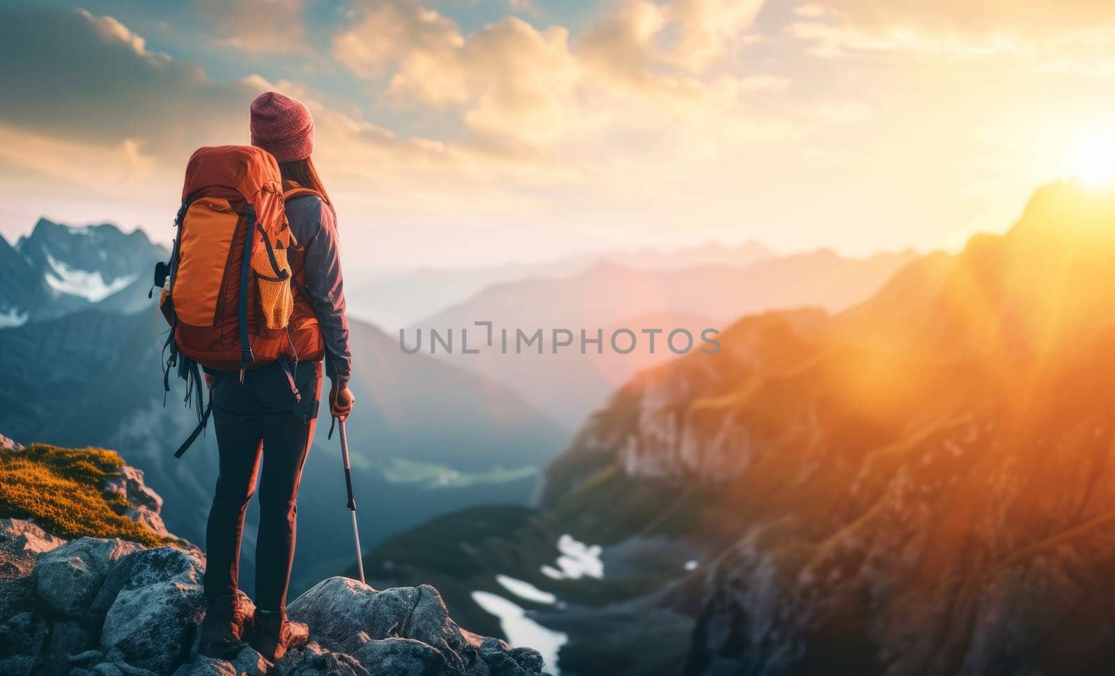 Hiker facing a stunning alpine sunrise with a backpack, standing on a mountain ridge