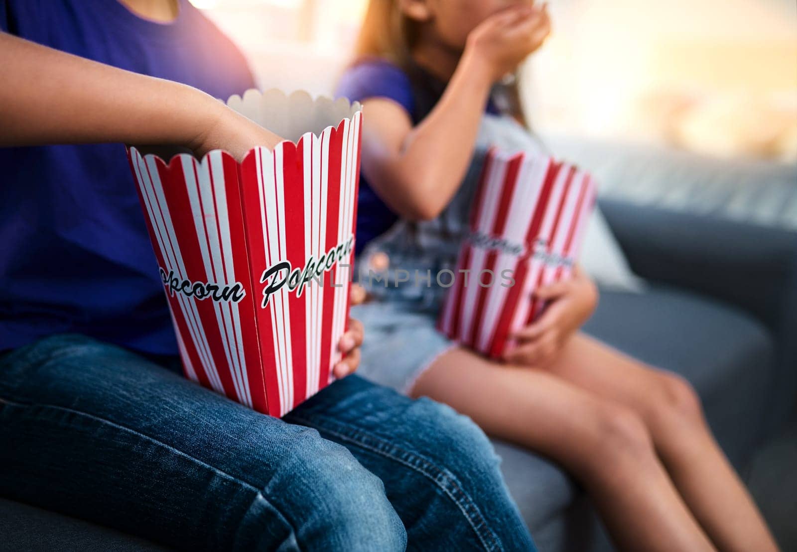 Children, popcorn and movie on couch in home, watching and television for entertainment. Video, living room and food or snack for relax and weekend, brother and sister in family house sofa streaming.