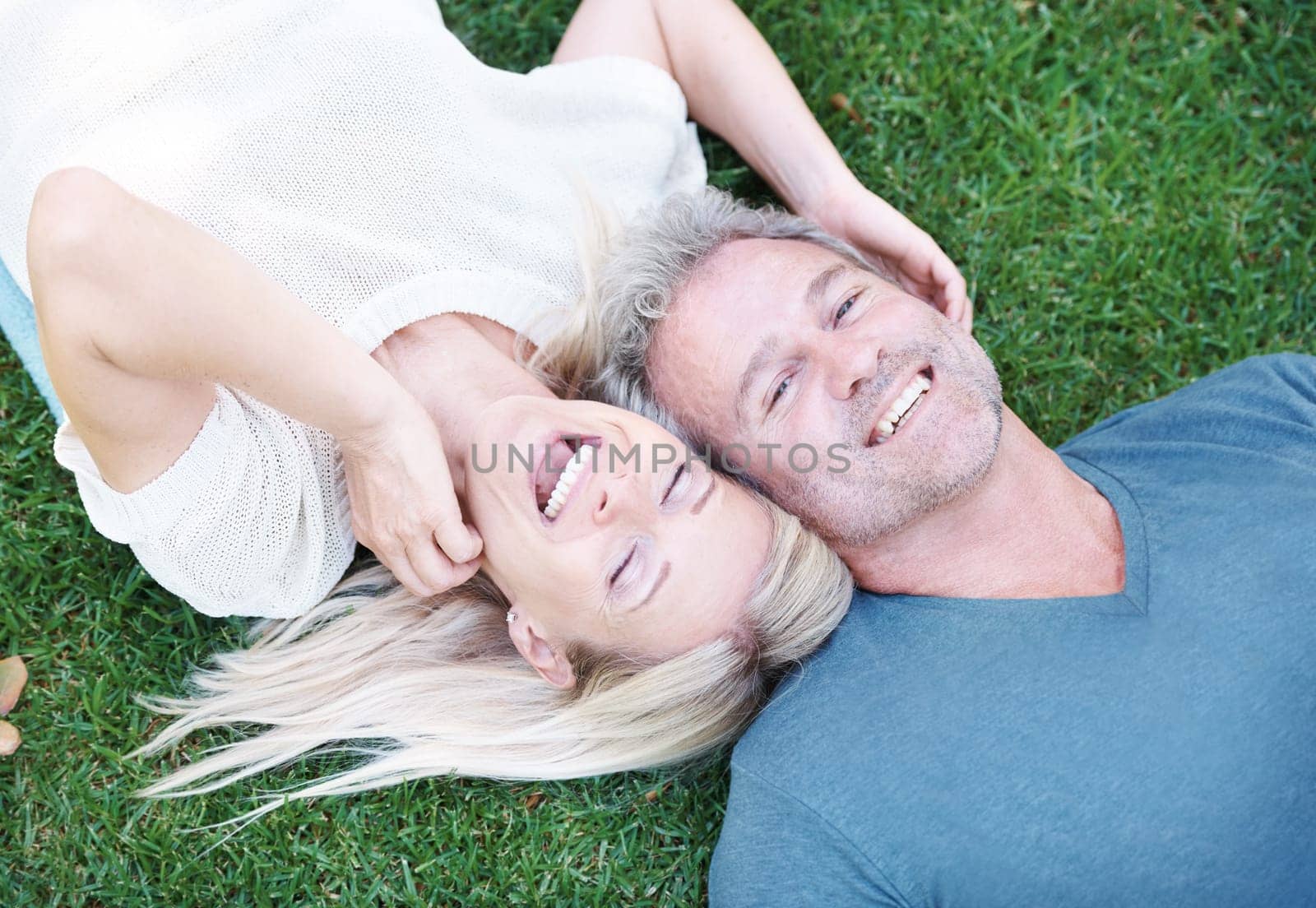 Mature, couple and laugh on grass or married connection for travel holiday on anniversary, date or bonding. Man, woman and from above or laughing for funny joke with humor together, field or summer by YuriArcurs