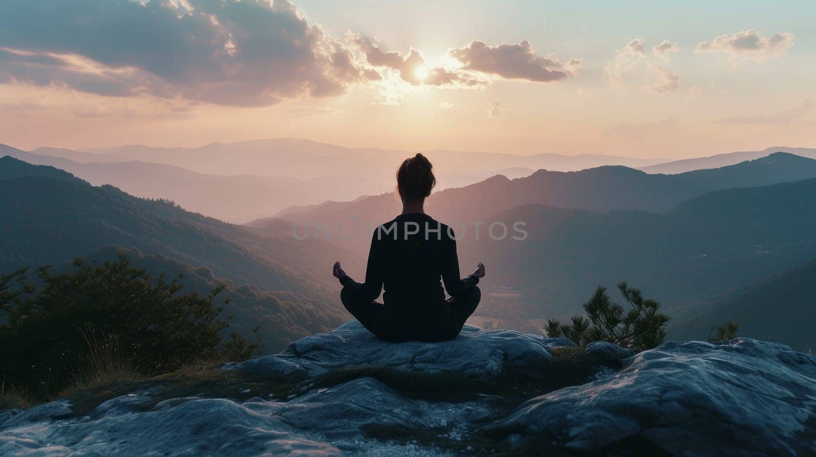 Individual meditating in a lotus pose on a mountain peak against a backdrop of a sunset sky