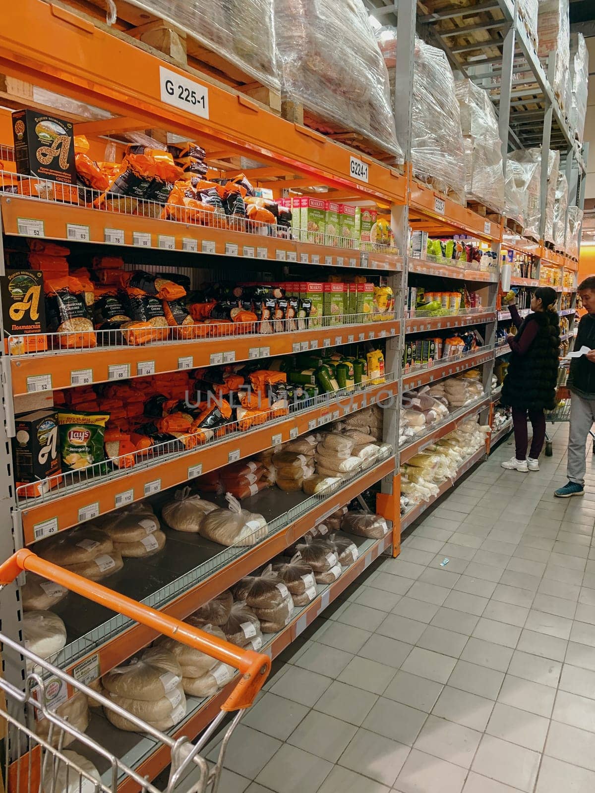 Bishkek, Kyrgyzstan - October 27, 2019: Supermarket. Megastore aisle with colorful shelves and unrecognizable customers as background.